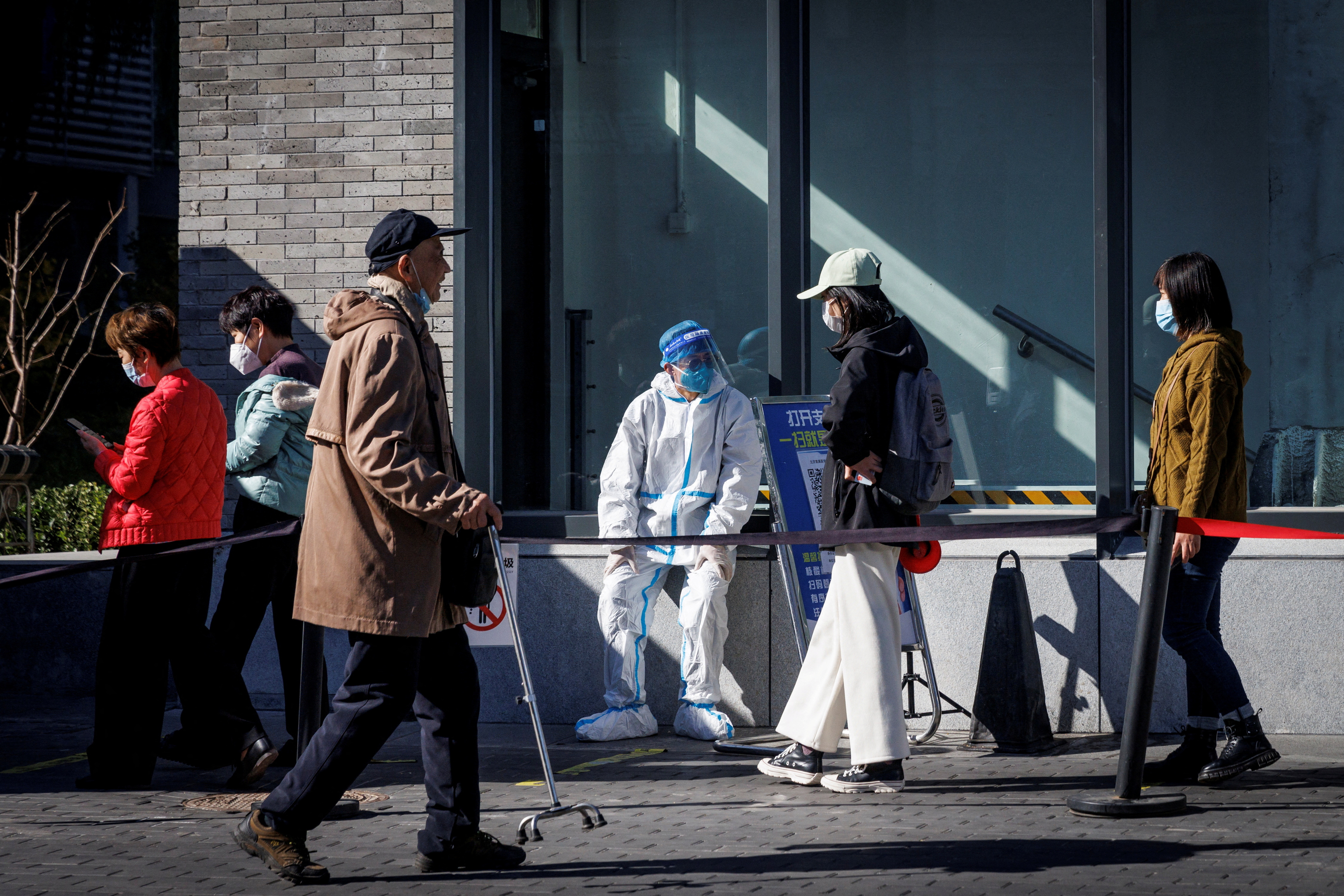A health worker wears a protective suit near a testing booth as outbreaks of coronavirus disease (COVID-19) continue in Beijing