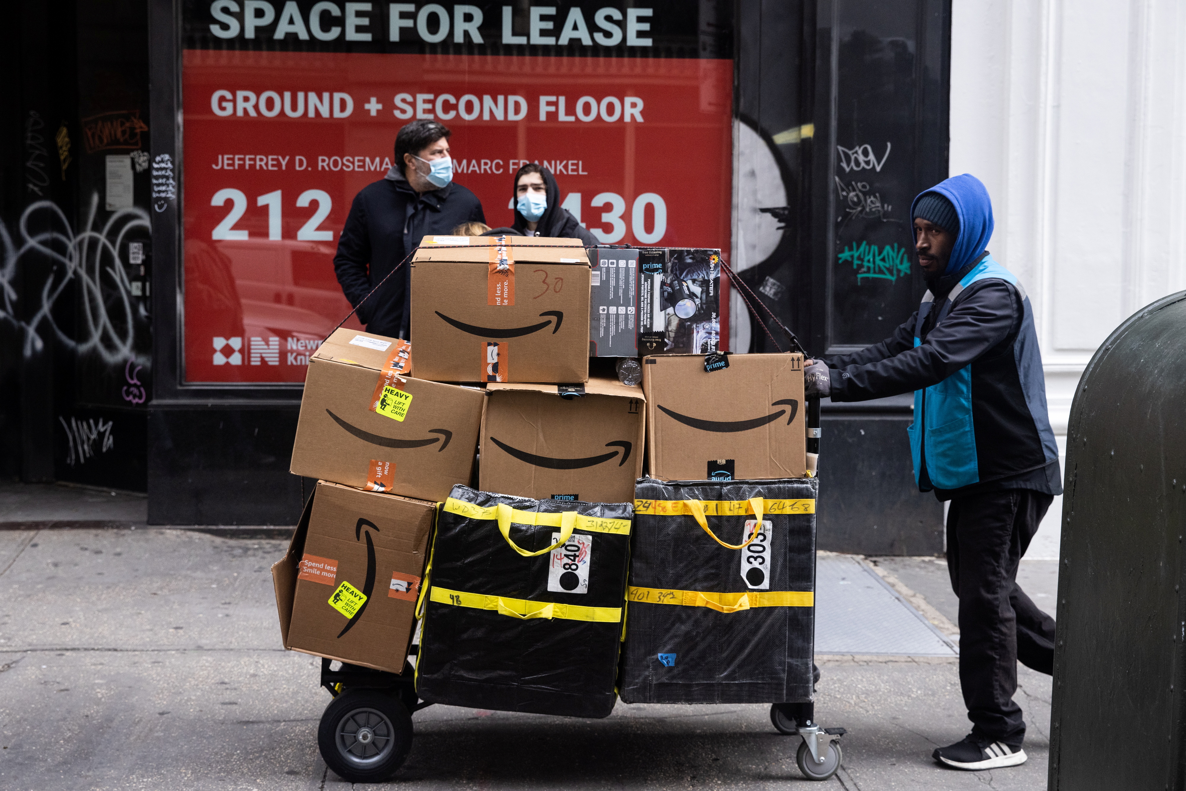 A delivery person pushes a cart full of Amazon boxes during Black Friday sales in the Manhattan borough of New York City, New York, U.S., November 26, 2021. REUTERS/Jeenah Moon