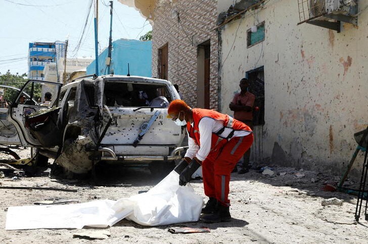 A paramedic handles a body bag  at the scene of an explosion Mogadishu