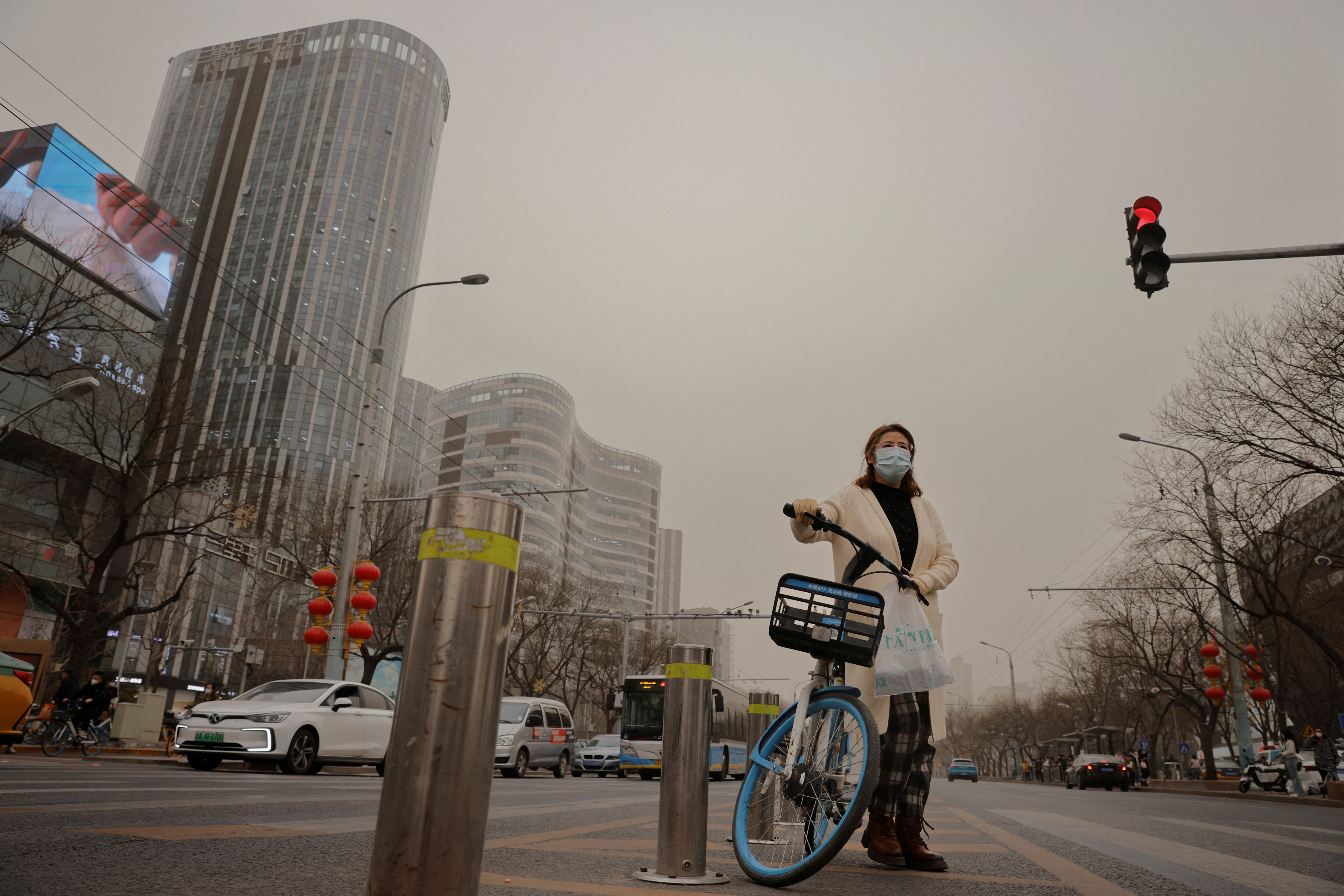 A cyclist waits to cross a street on a polluted day in Beijing