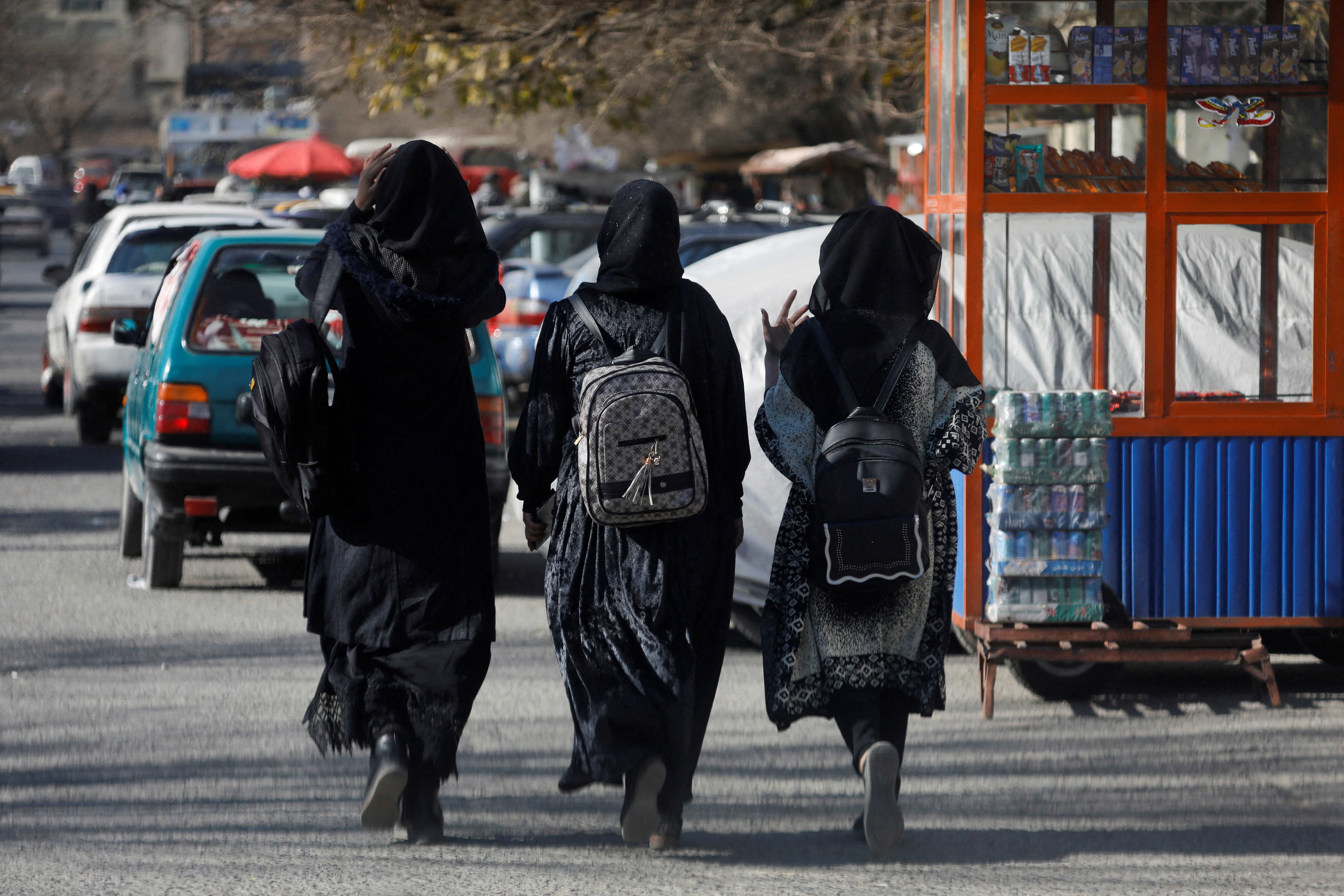 Afghan female students walk near Kabul University in Kabul