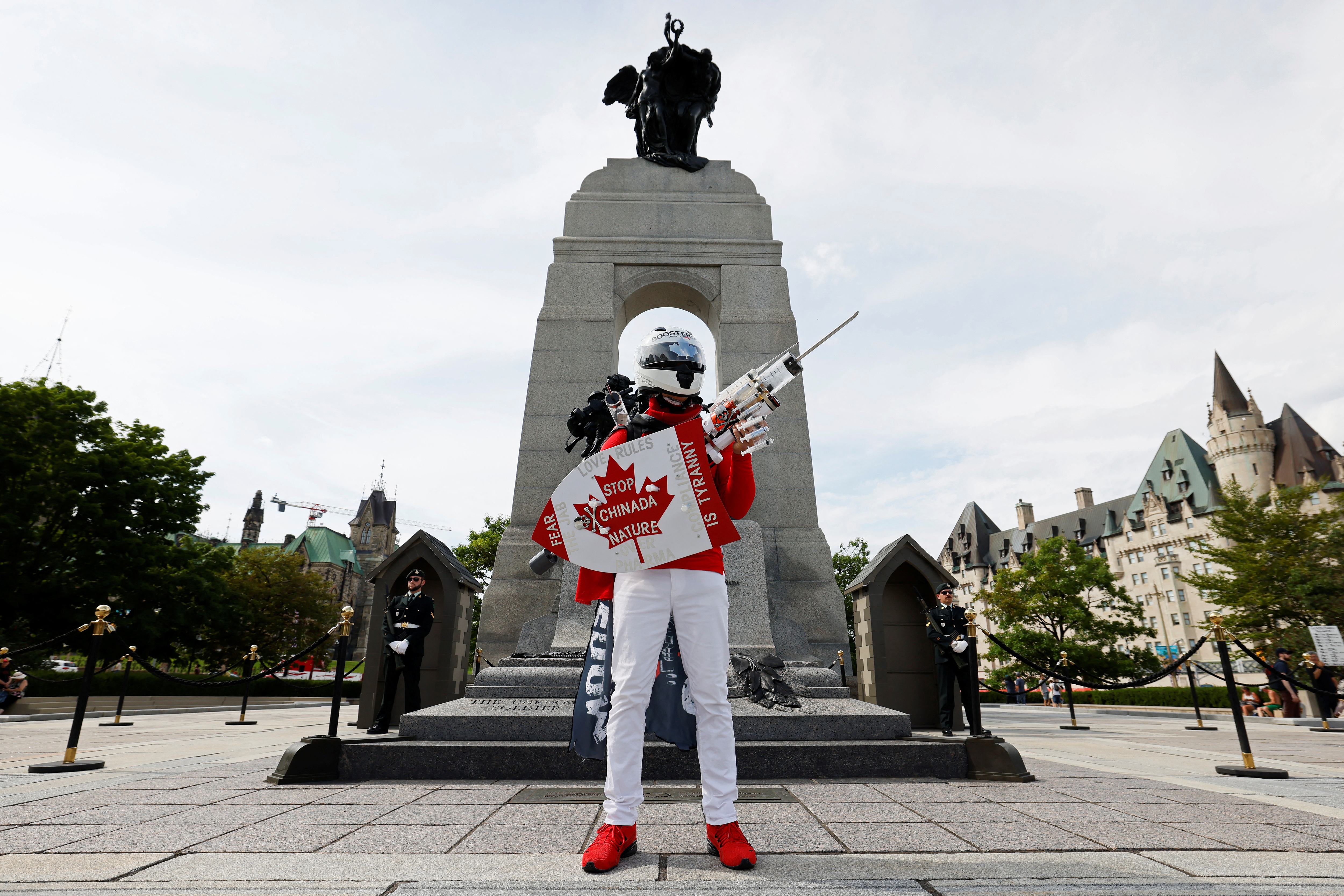 A anti-vaccine protester poses at the National War Memorial in Ottawa