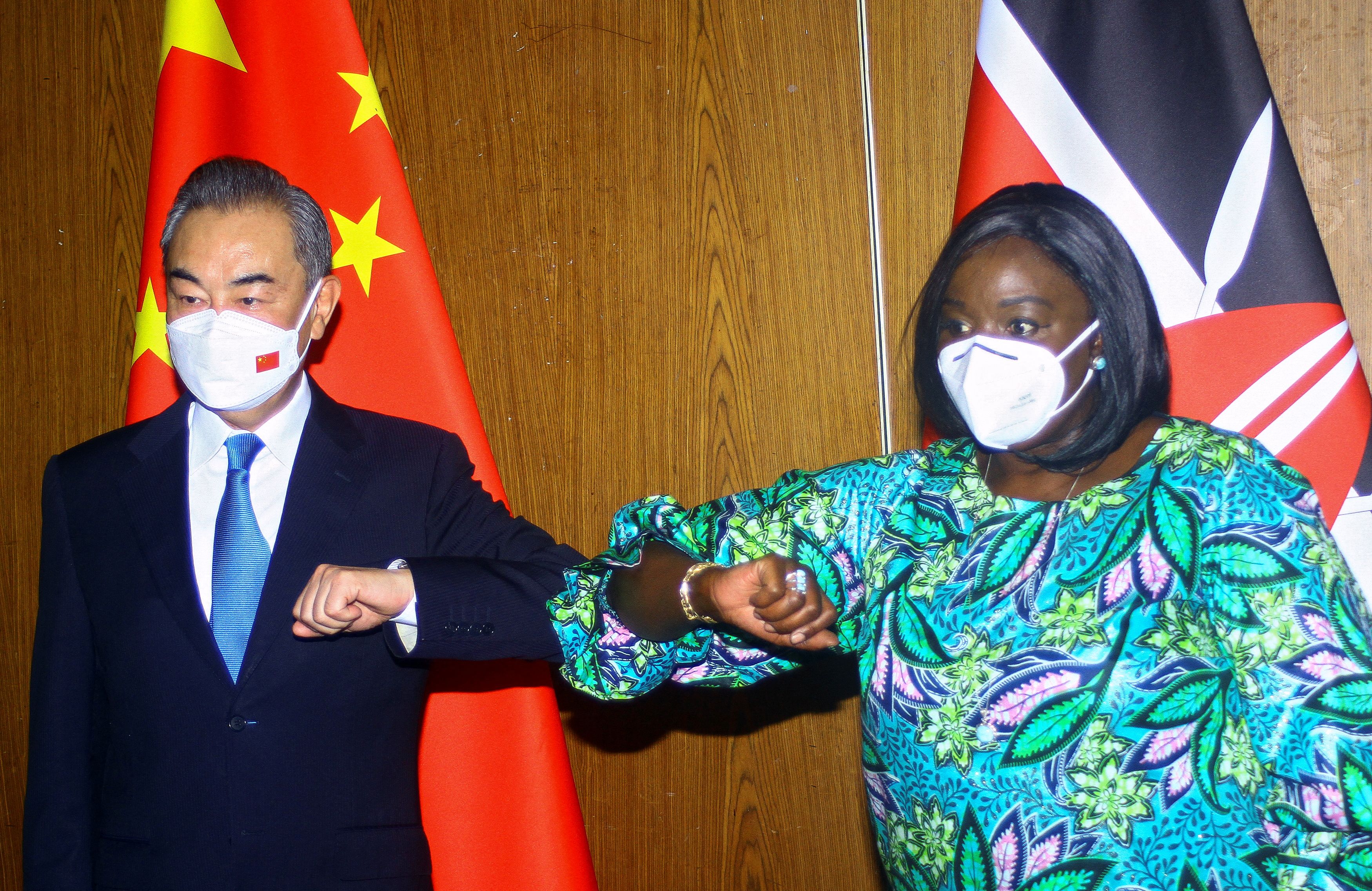Le ministre chinois des Affaires étrangères Wang Yi et son homologue kenyan Raychelle Omamo se cognent les coudes lors d'une conférence de presse dans la ville côtière de Mombasa, au Kenya, le 6 janvier 2022. REUTERS/Joseph Okanga