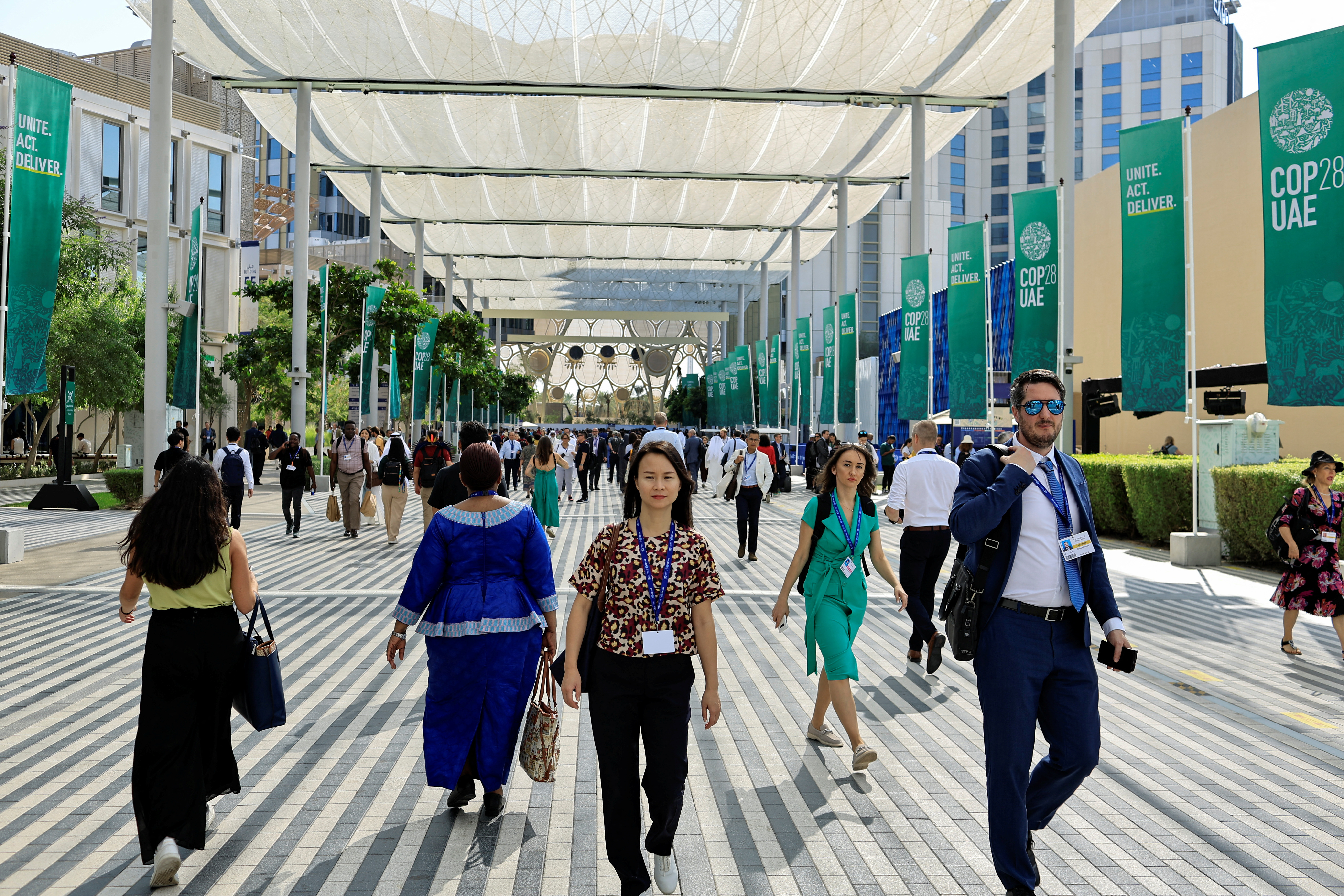 Delegados caminham na Expo City de Dubai durante a Conferência das Nações Unidas sobre Mudanças Climáticas (COP28) em Dubai