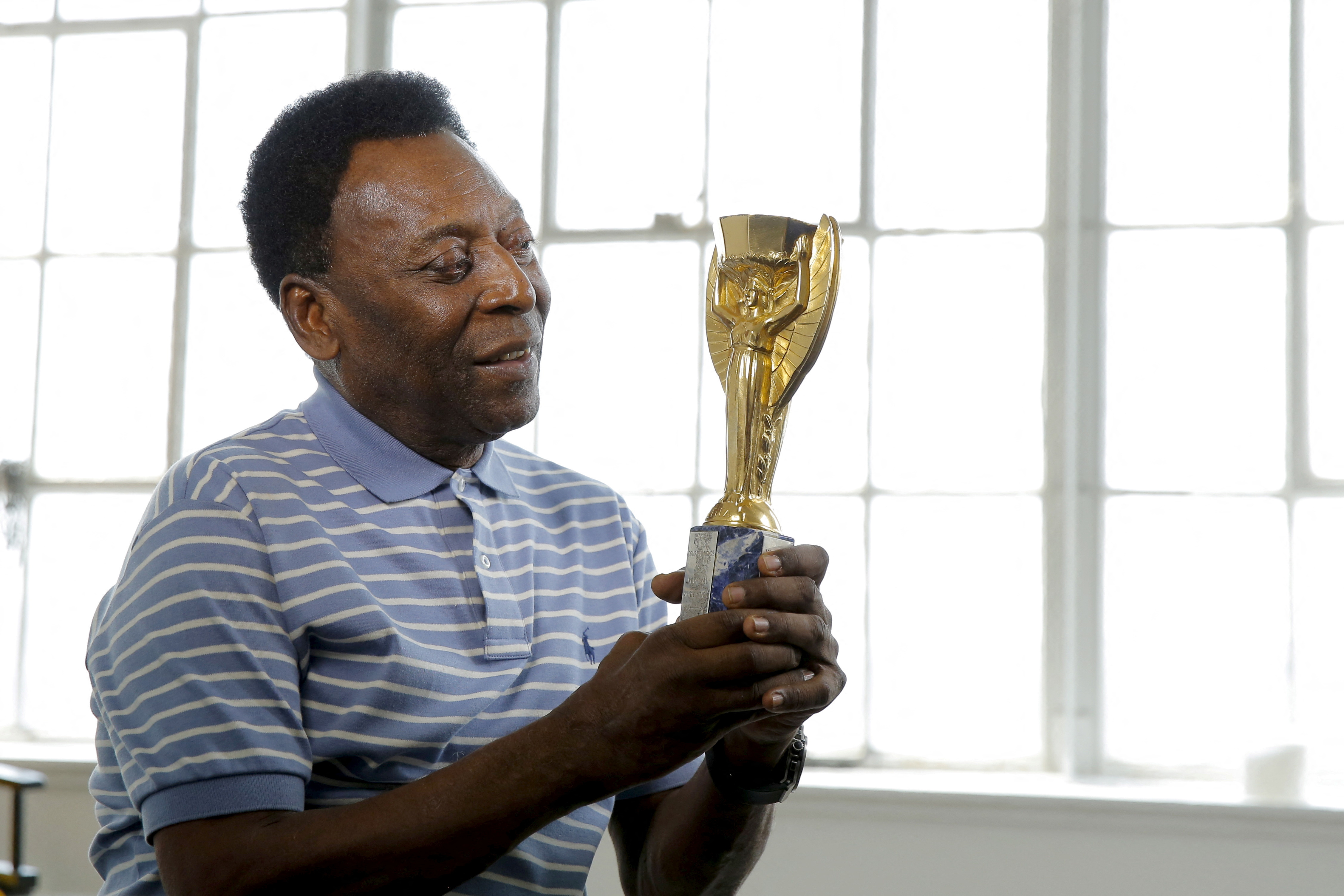 Legendary Brazilian soccer player Pele poses for a portrait with his 1958 World Cup trophy during an interview in New York