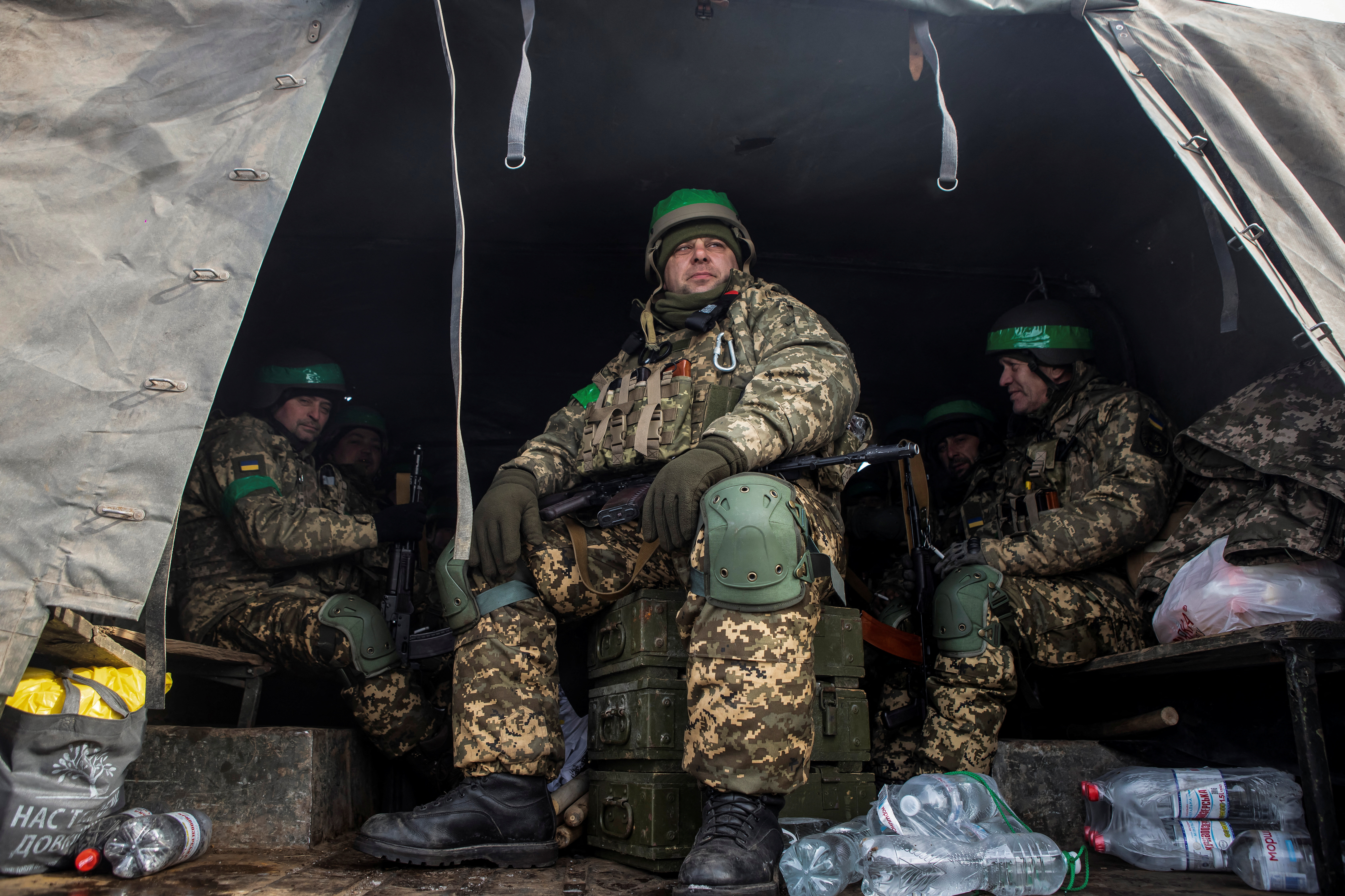 Ukrainian servicemen sit inside a military truck on a road outside the frontline town of Bakhmut