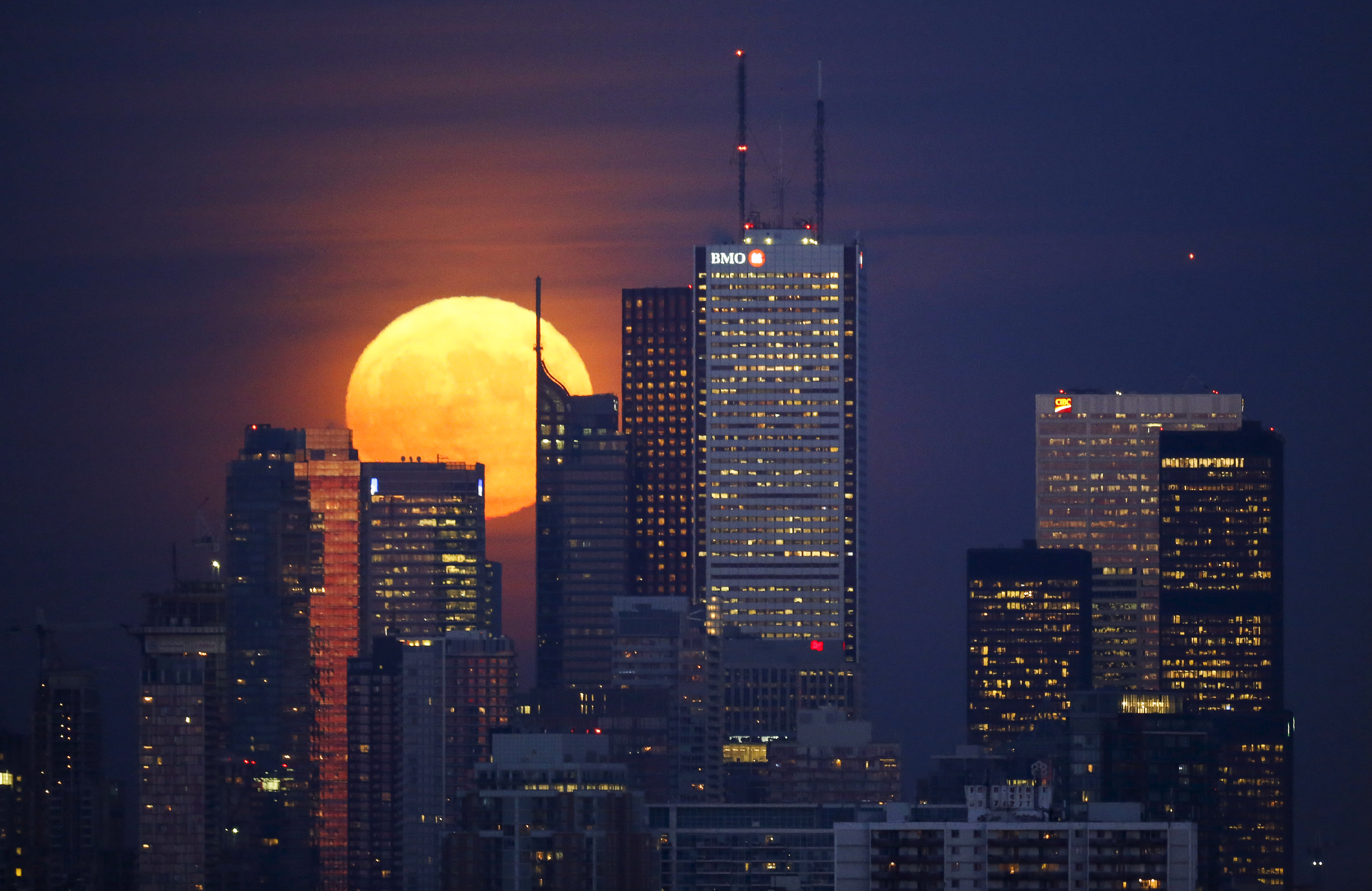 La luna se eleva detrás del horizonte y el distrito financiero de Toronto