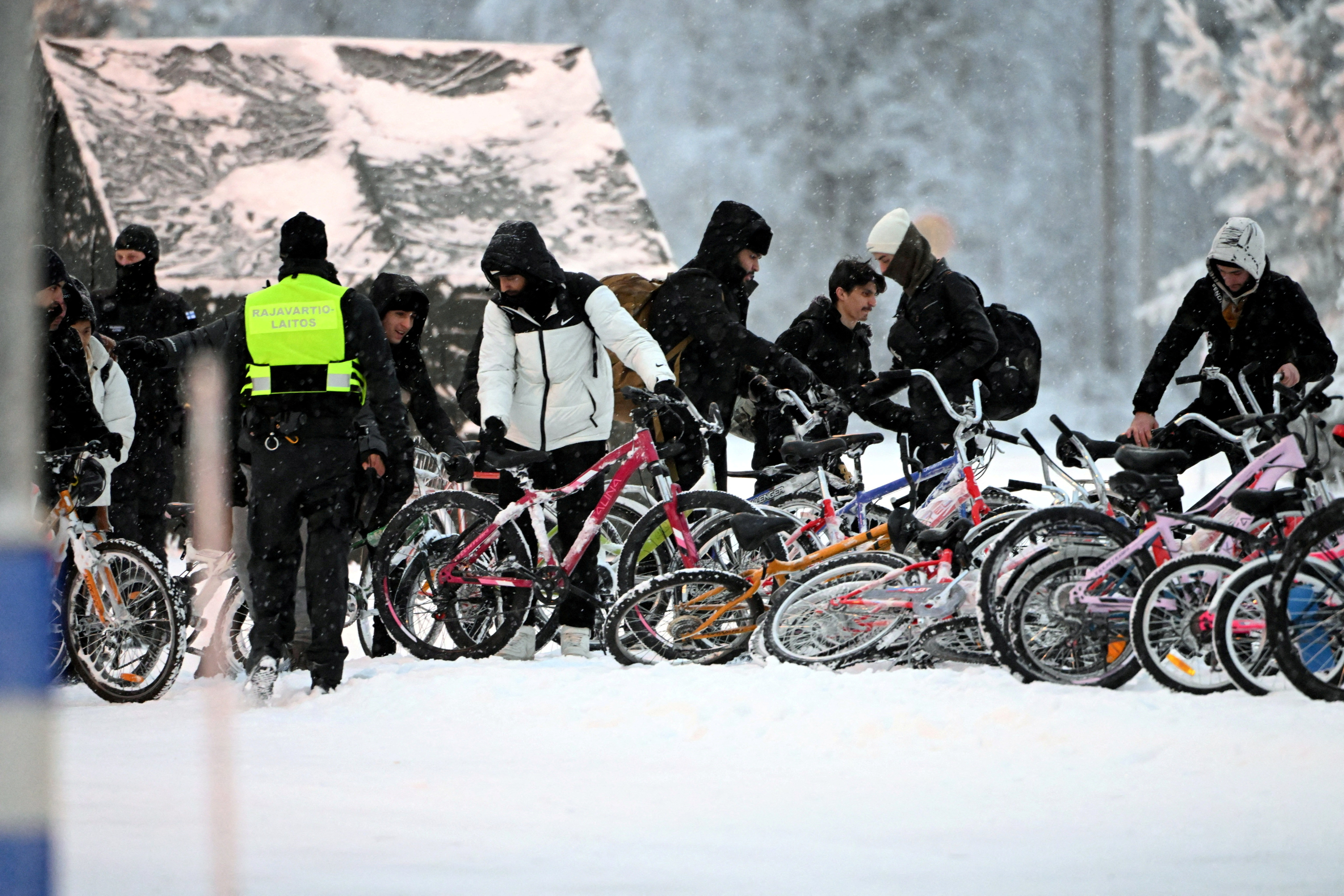 Migrants arrive with bicycles to the international border crossing at Salla