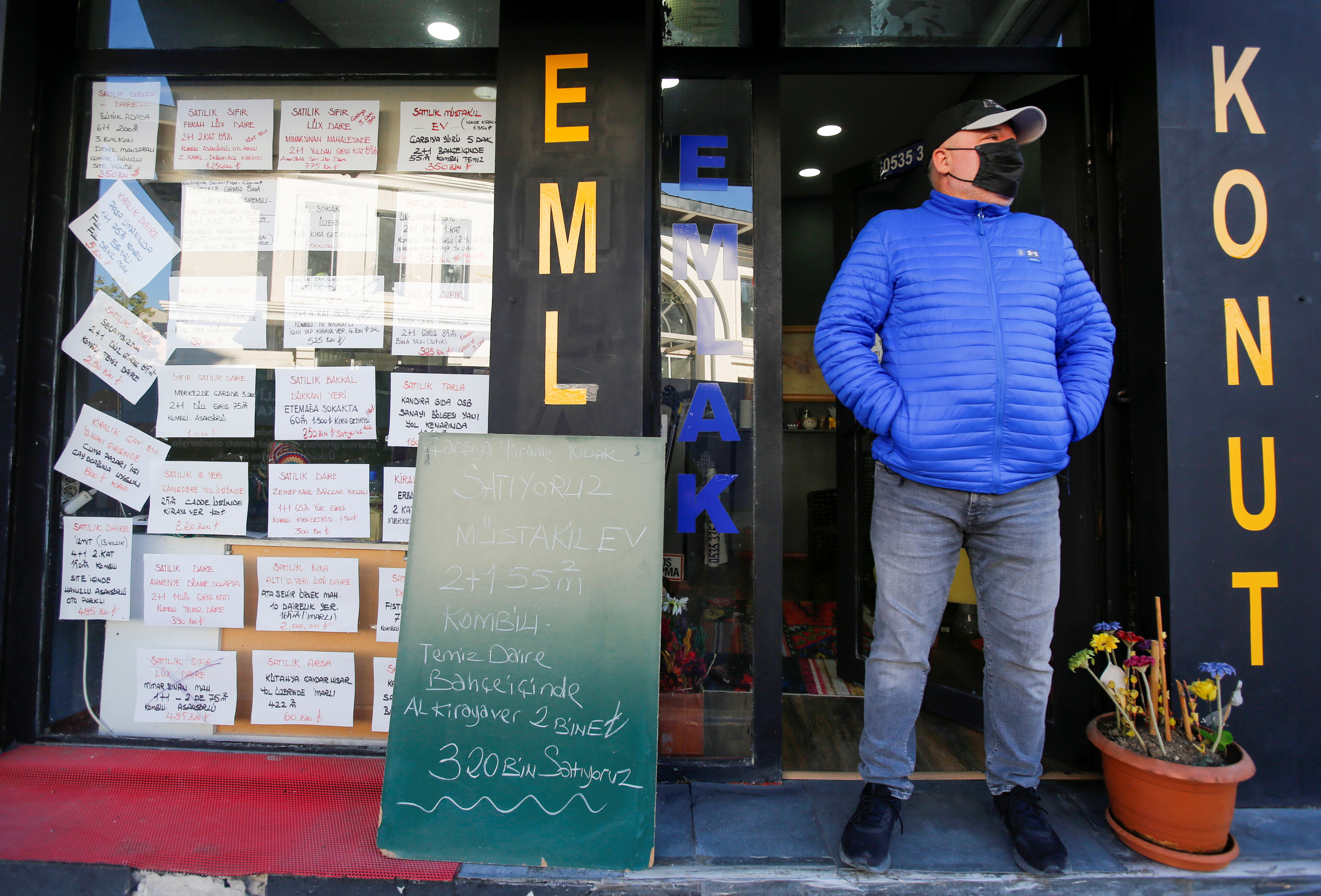 An estate agent stands at the entrance to his office in Istanbul