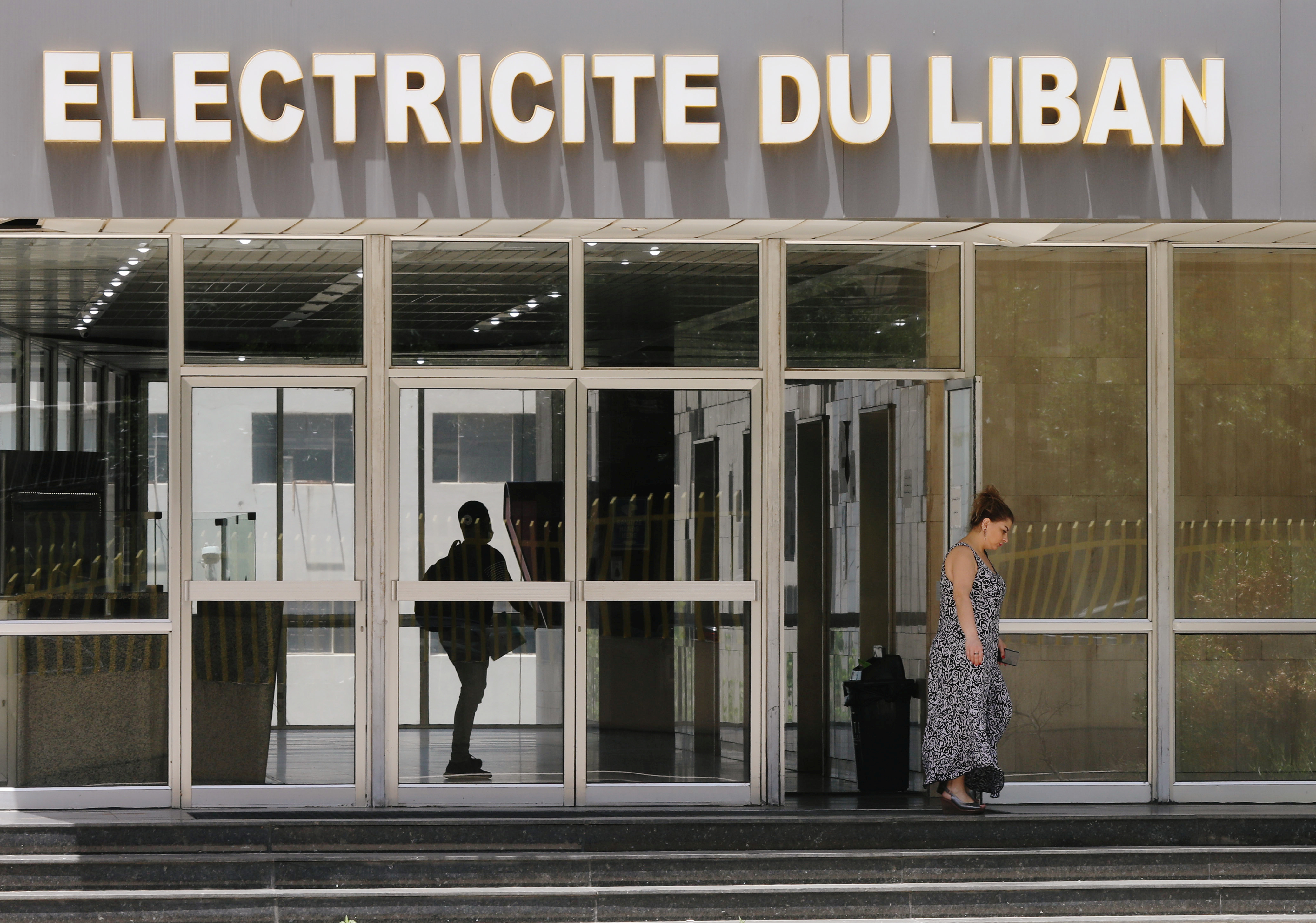 A woman walks outside a building of a Lebanon's electricity company in Beirut
