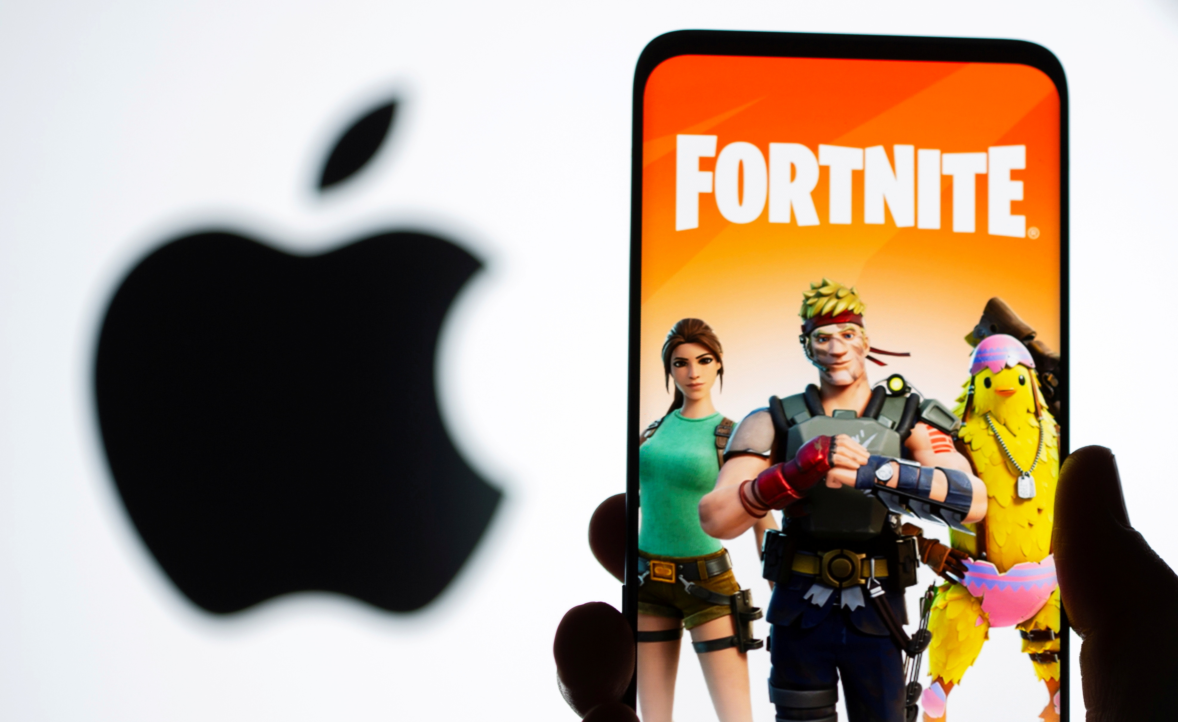 Fortnite game graphic is displayed on a smartphone in front of Apple logo in this illustration taken May 2, 2021. REUTERS/Dado Ruvic/Illustration/File Photo