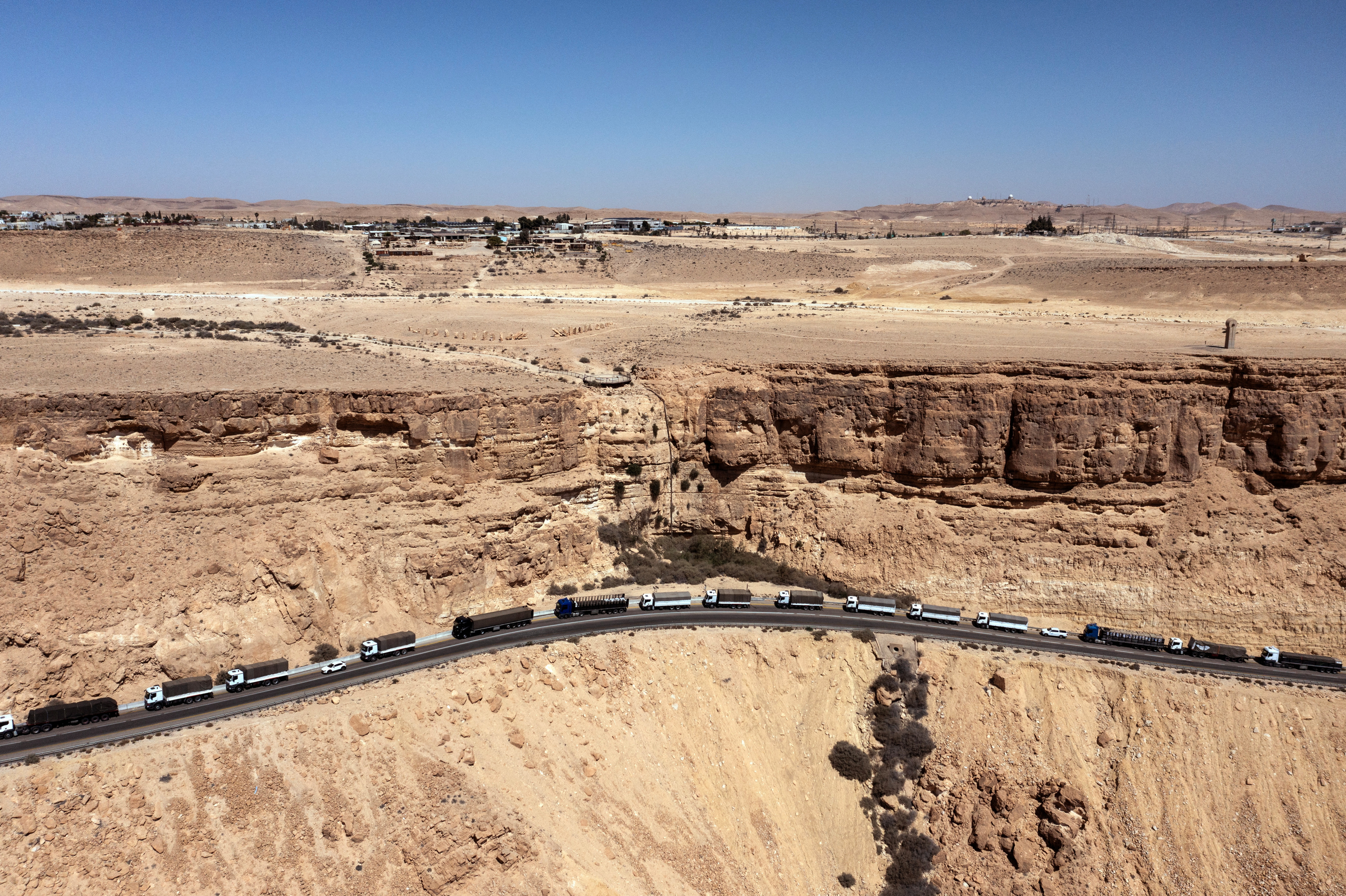 A drone view shows a trail of trucks lining up on a road near Mitzpe Ramon following a protest aiming to prevent humanitarian aid from arriving to Gaza, near Mitzpe Ramon, southern Israel