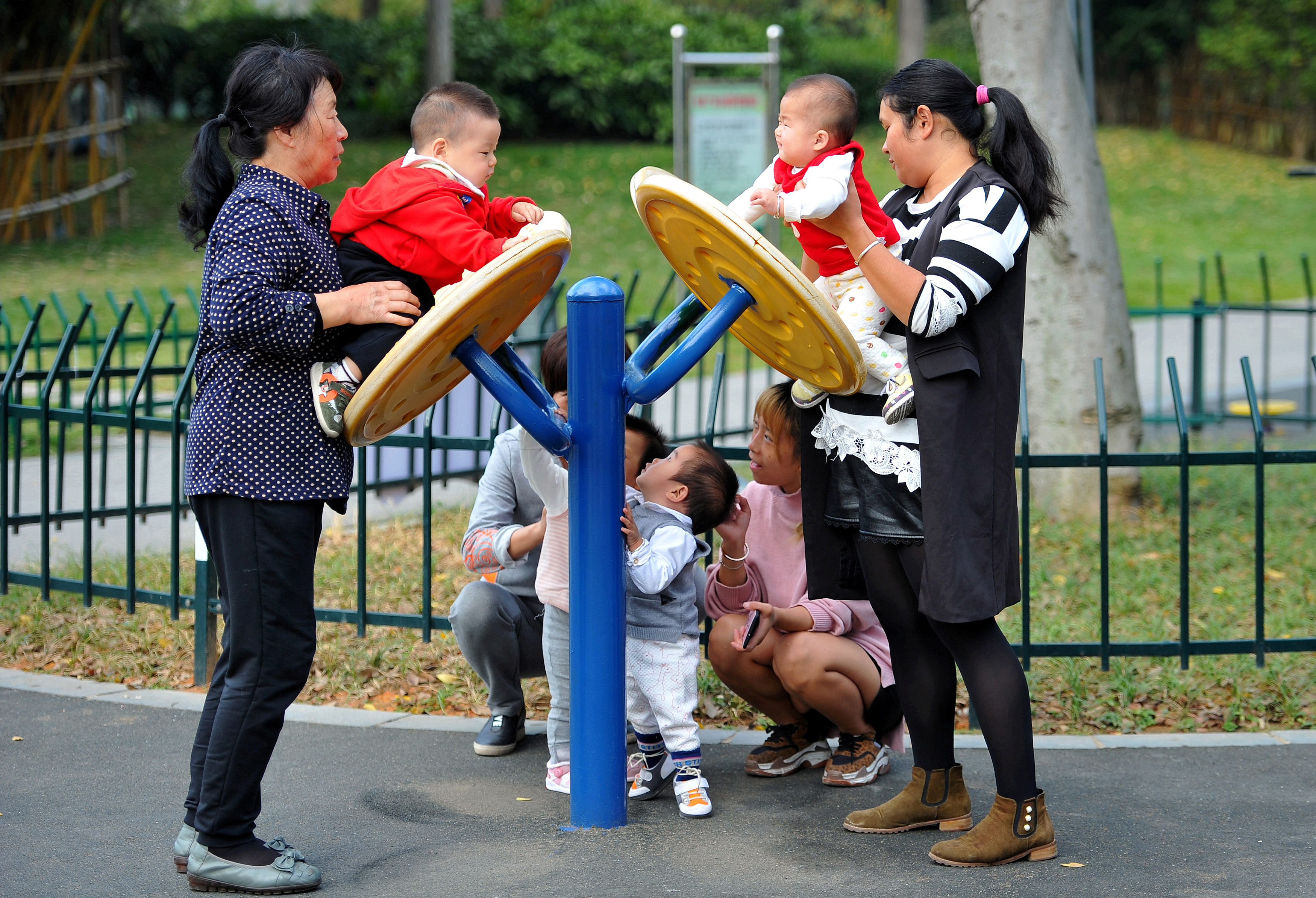 Women play with children at a park in Jinhua, Zhejiang province