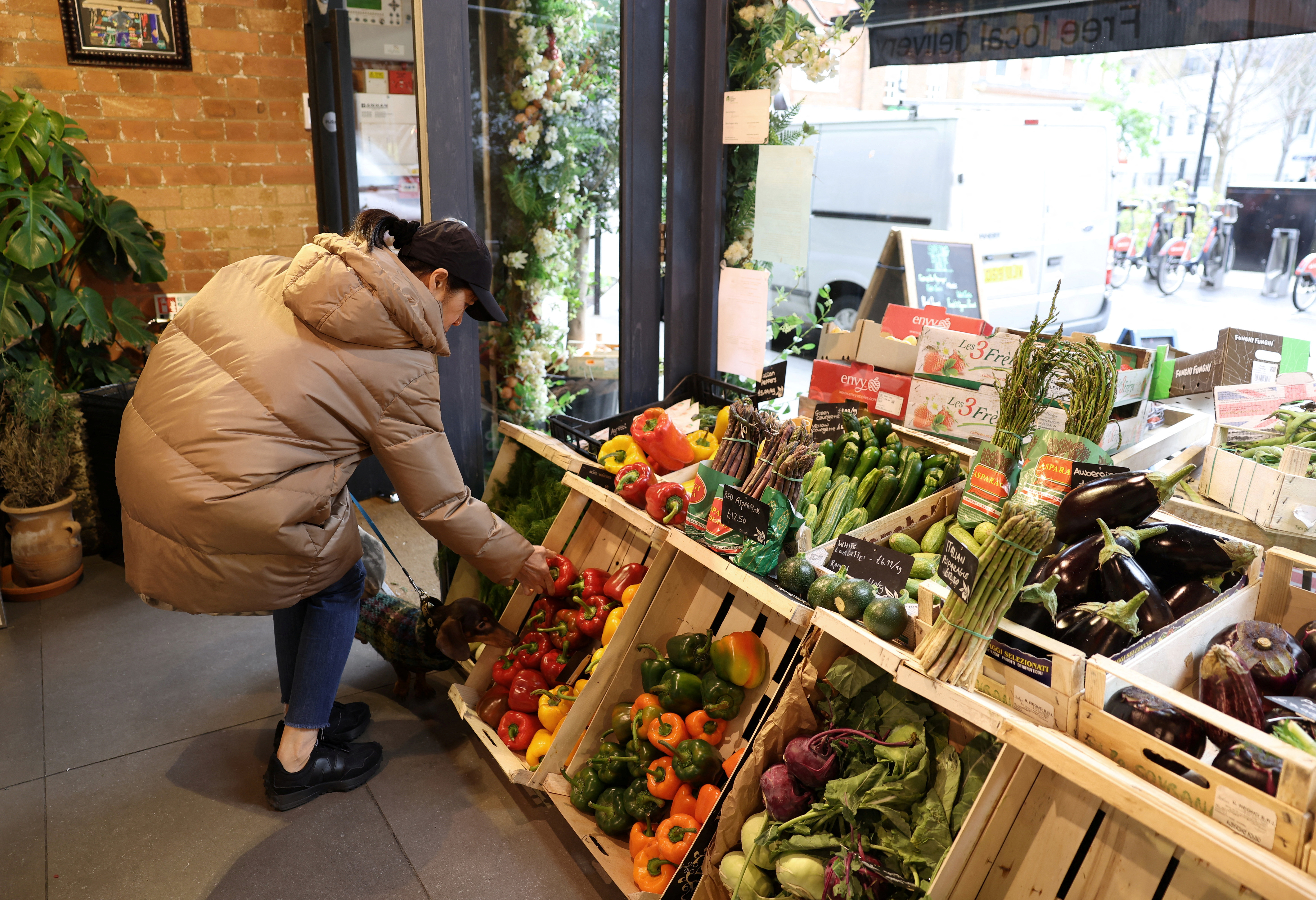 A customer shops for vegetables at gourmet grocery store Andreas, in London