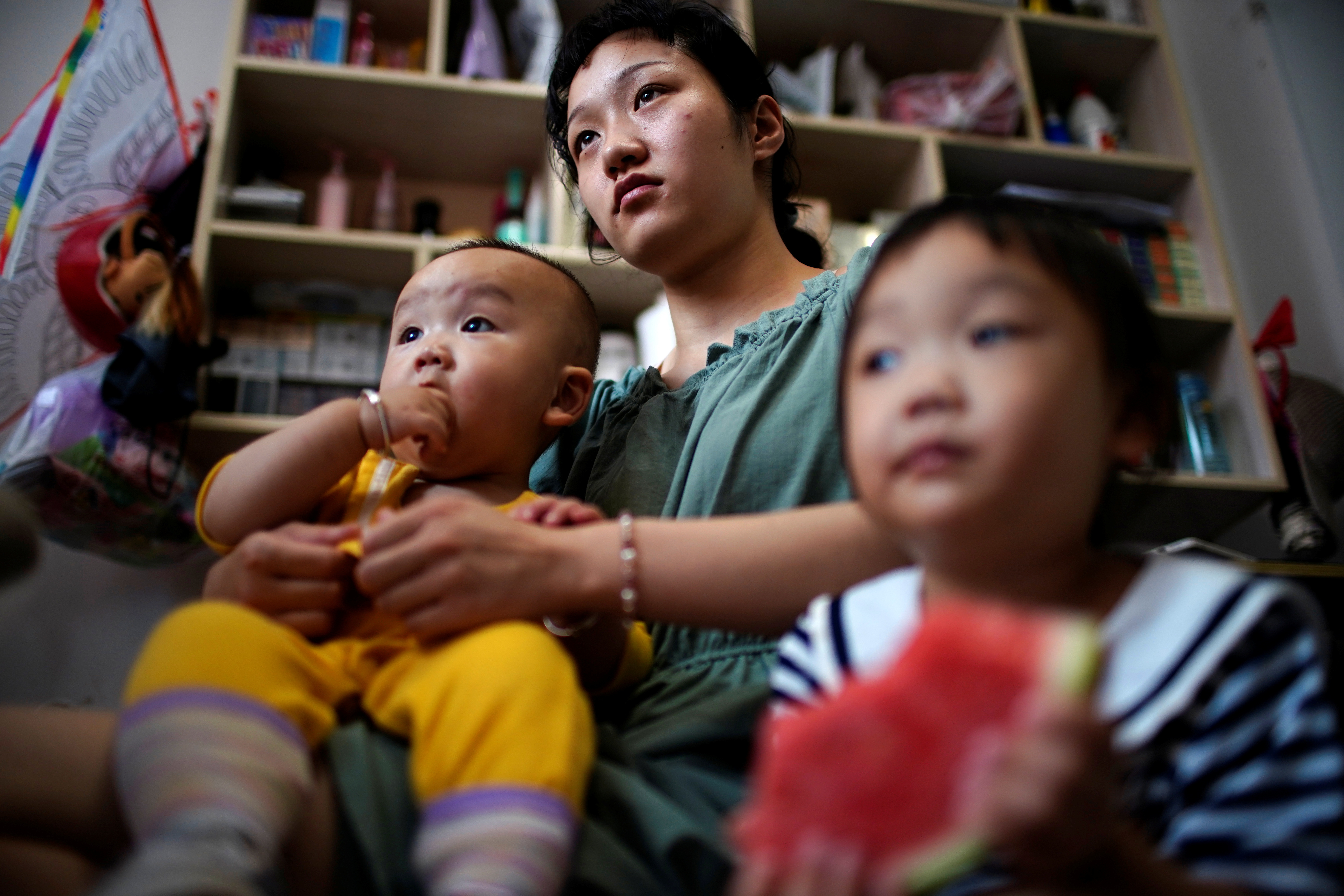 Sun Yan poses for her two children in her barbershop on the outskirts of Shanghai