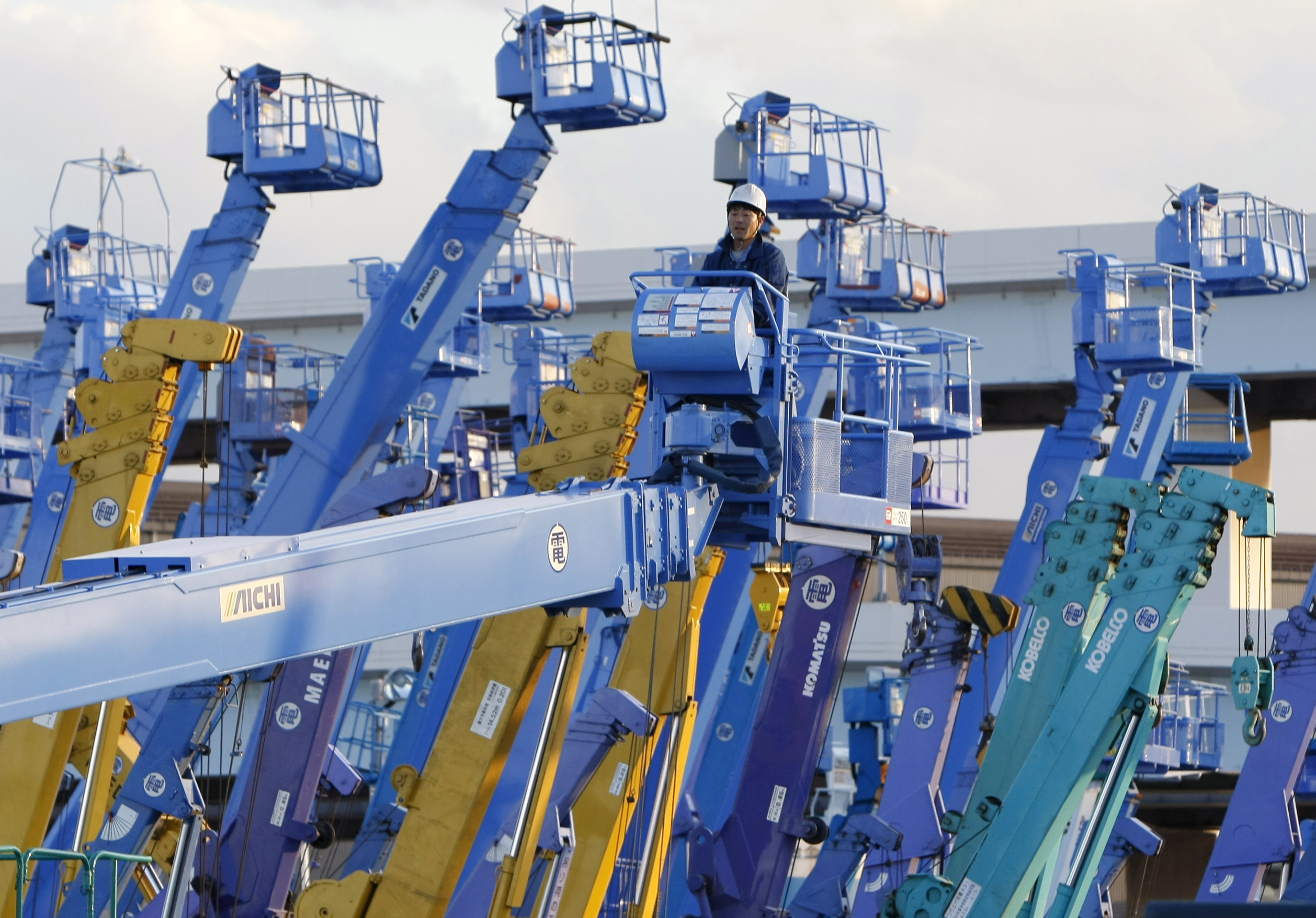 A worker stands on a crane which is parked at a construction site at Keihin industrial zone in Kawasaki