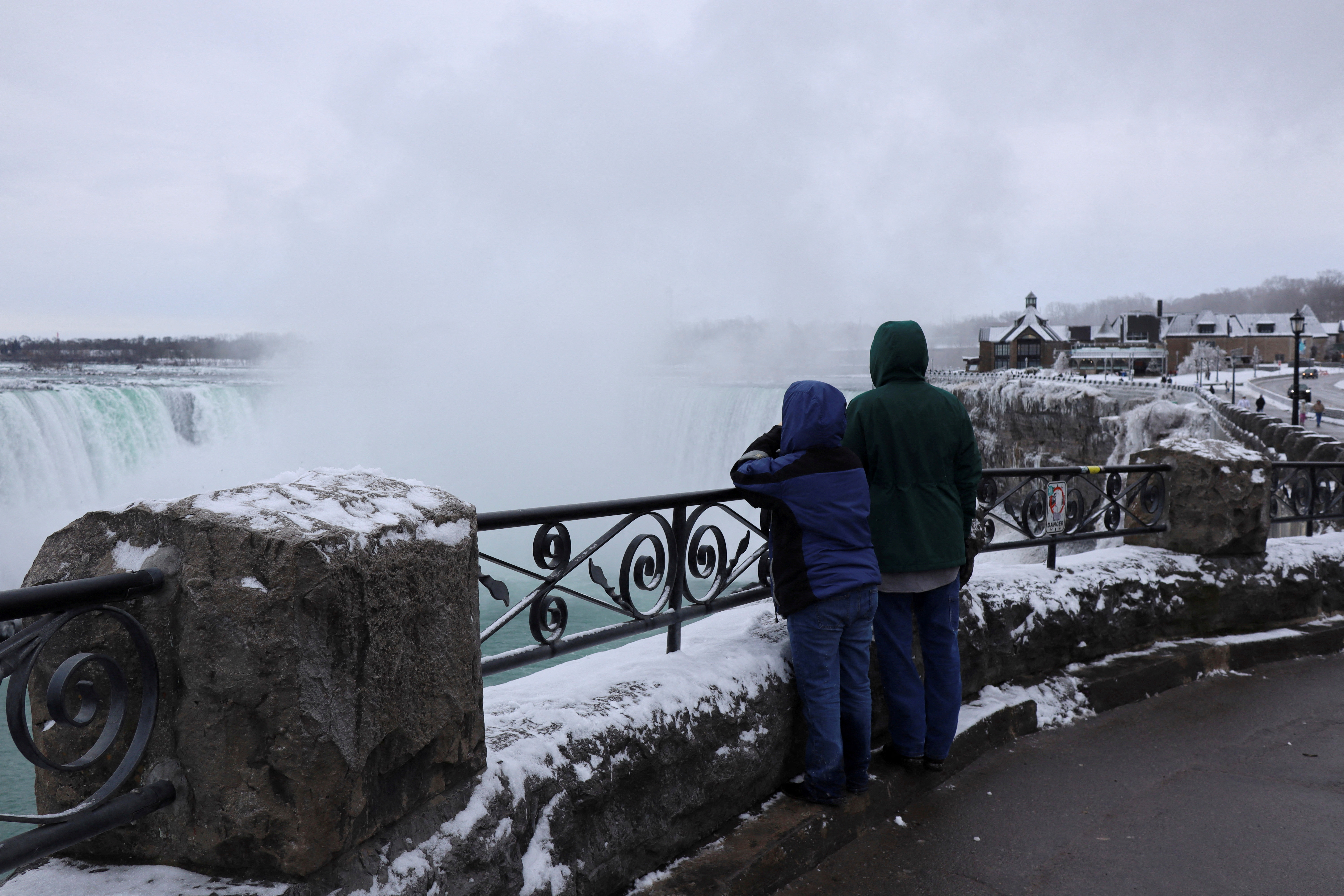 Tourists view mist rising from the Horseshoe Falls while visiting Niagara Falls, Ontario