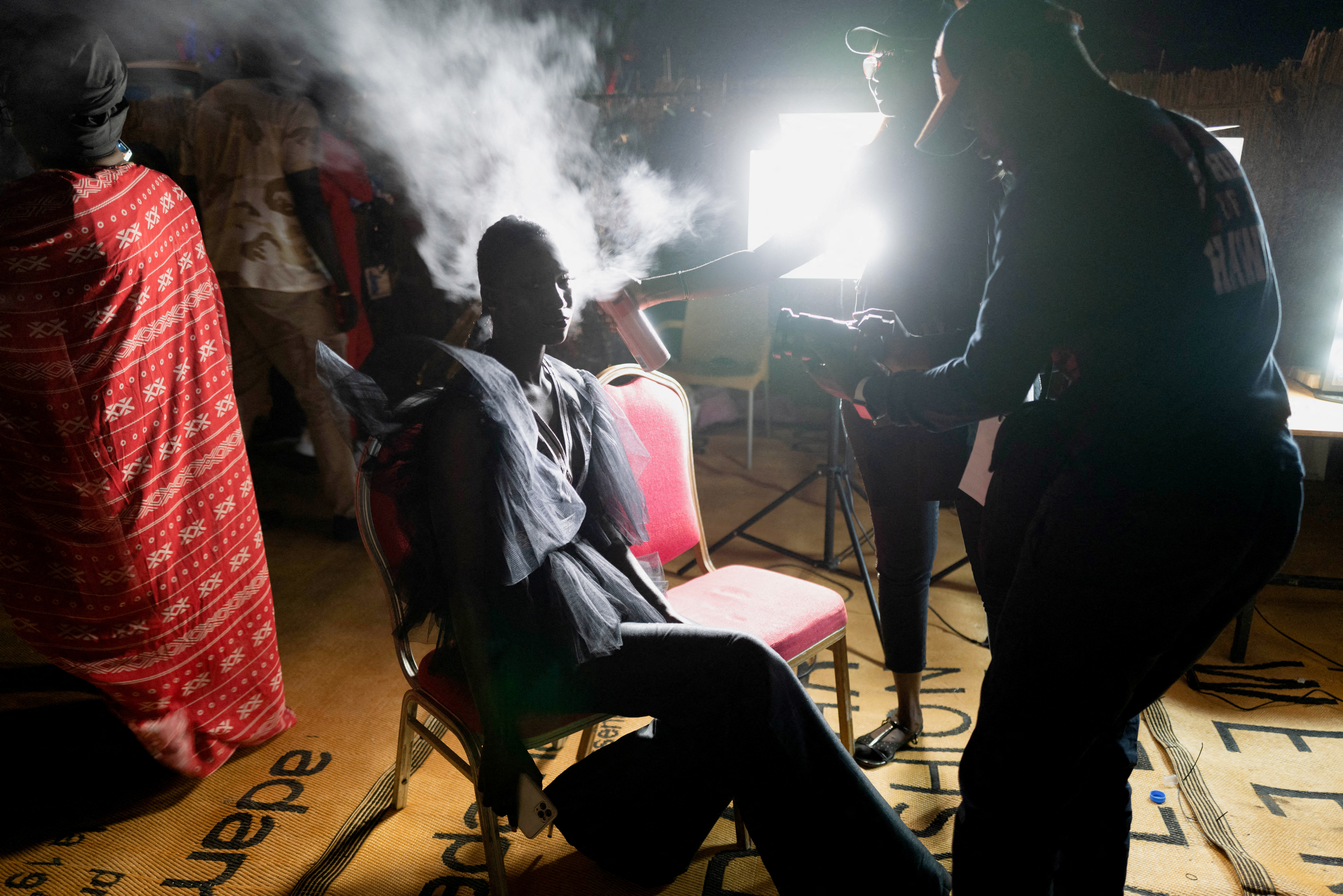 A model prepares backstage before a show of the 19th annual Dakar Fashion Week, at the Baobad forest, in Mbour