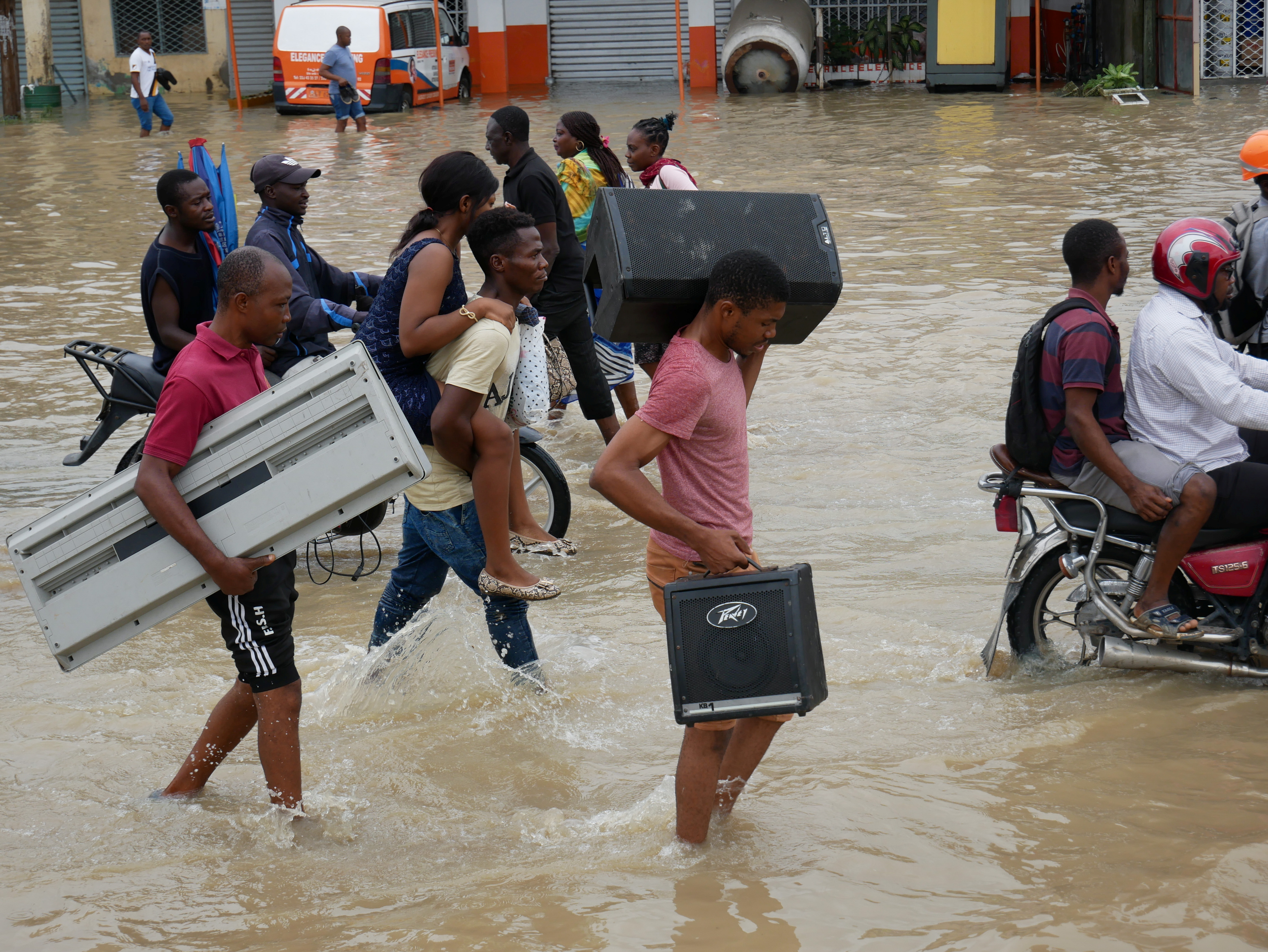 Residents make their way through a flooded street after the heavy rains in Douala