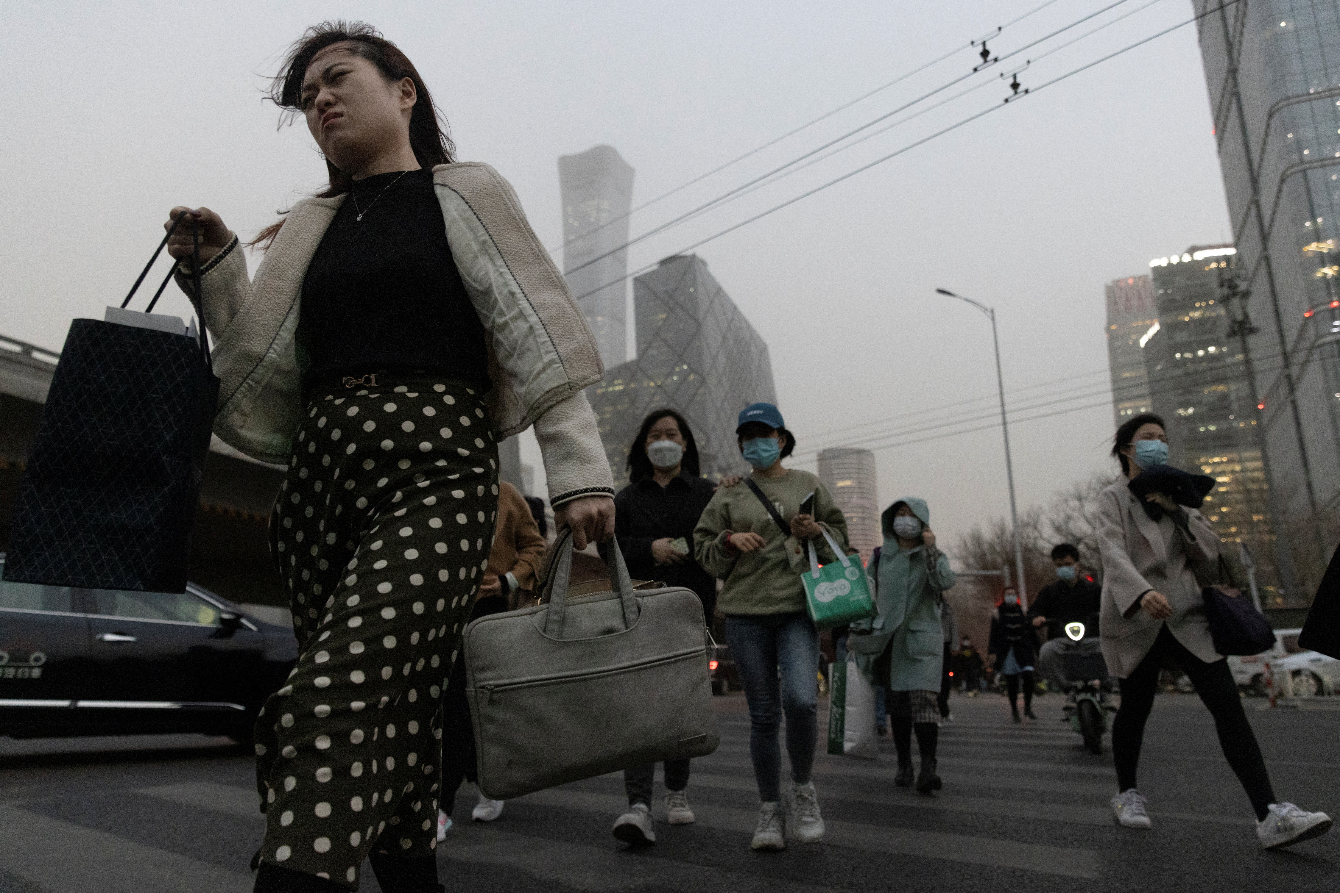 People cross a street in the Central Business District (CBD) on a polluted day in Beijing