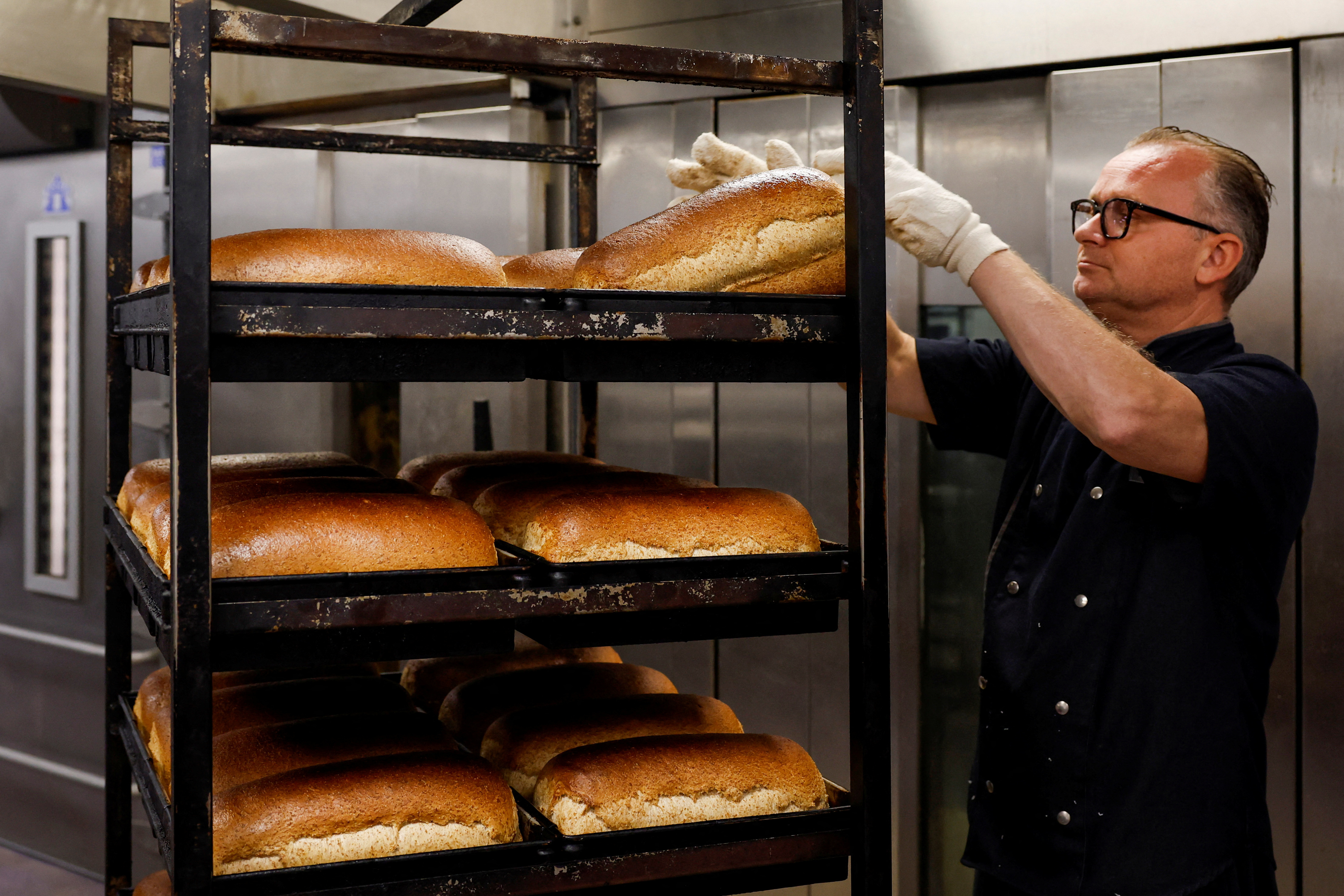 Owner Dennis Toebast takes the bread out of the oven at his bakery in Hoevelaken