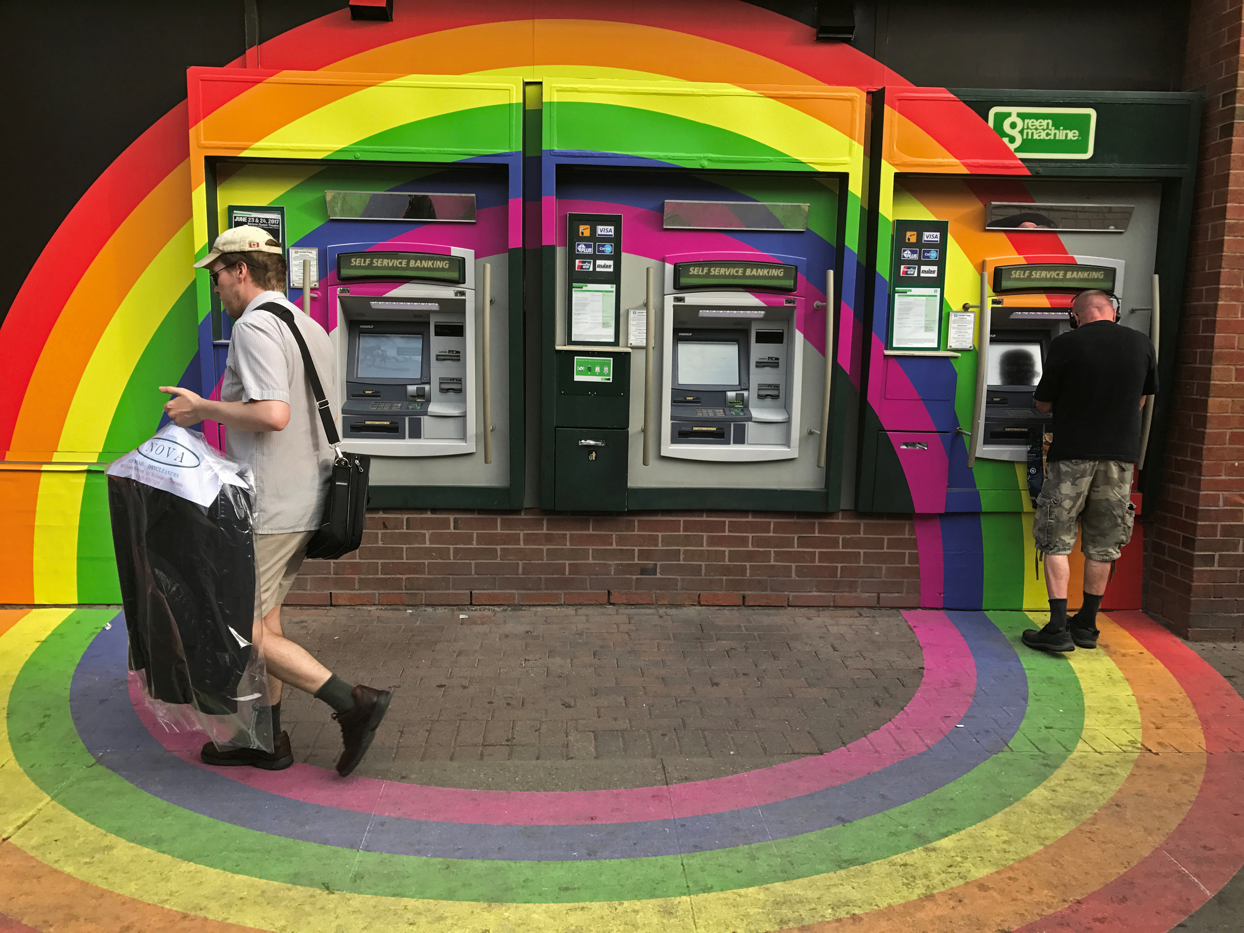 A customer withdraws money from an ATM at a Toronto-Dominion (TD) bank branch adorned in colours of the Pride rainbow flag symbolizing gay rights, in downtown Toronto, Ontario, Canada June 13, 2017.  REUTERS/Chris Helgren