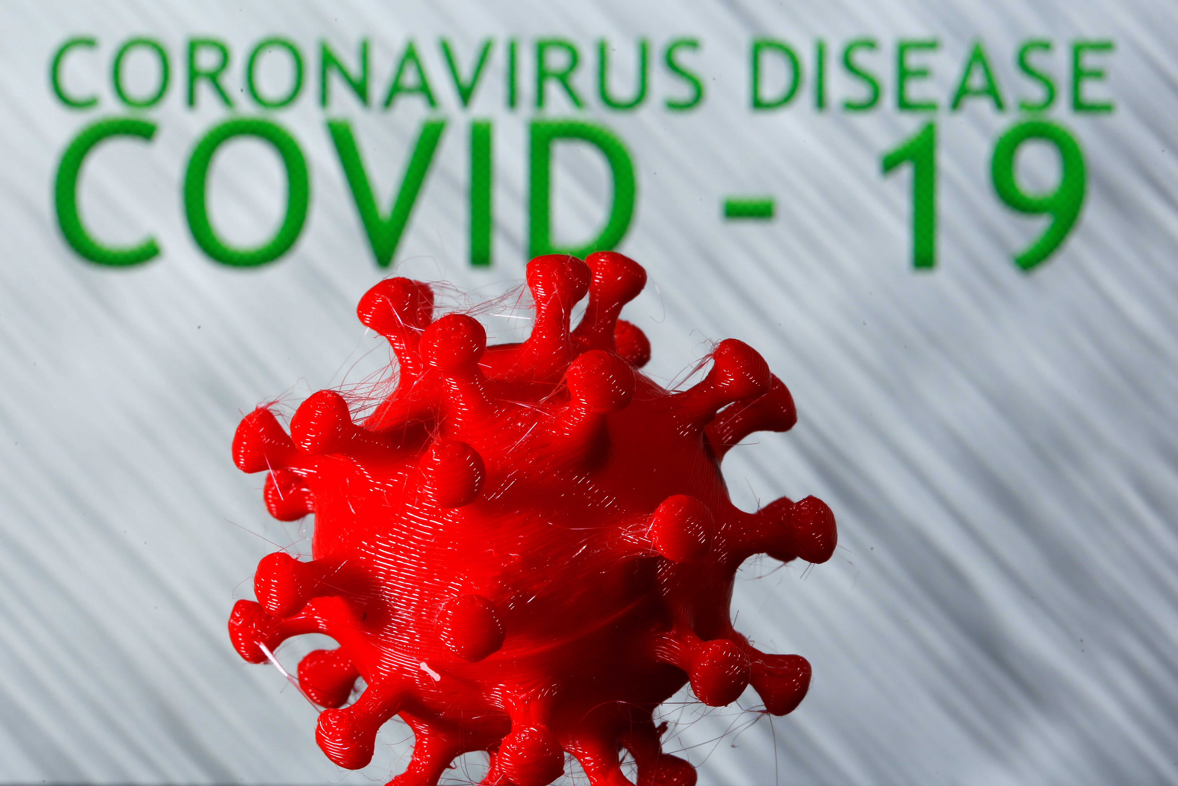 En 3D-printet koronavirusmodell er sett foran ordene koronavirussykdom (Covid-19) utstilt i denne illustrasjonen