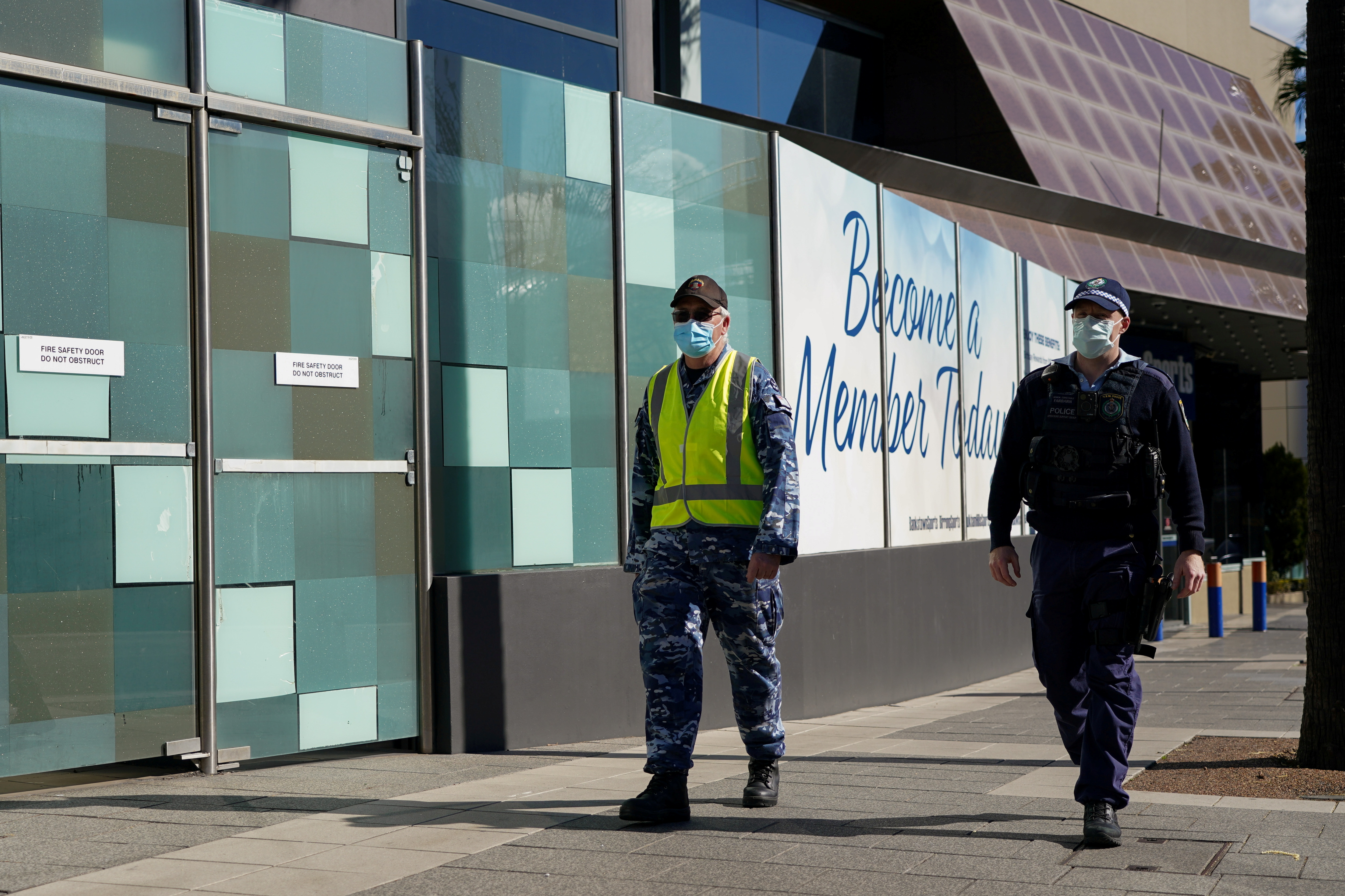Personnel from the Australian Defence Force and New South Wales Police Force patrol a street in Sydney's Bankstown suburb during an outbreak of the coronavirus disease