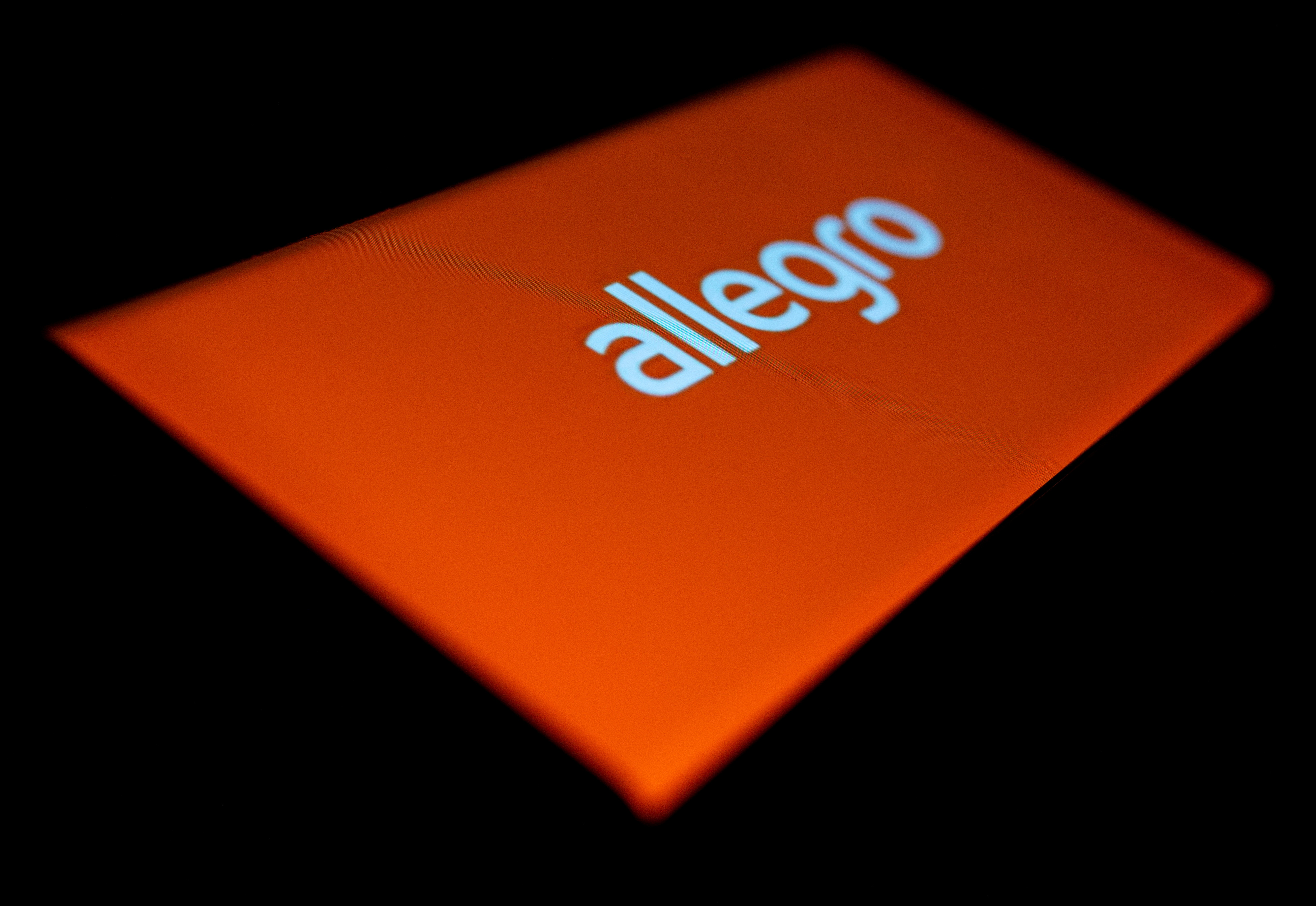 Allegro logo is seen on the smartphone in this illustration