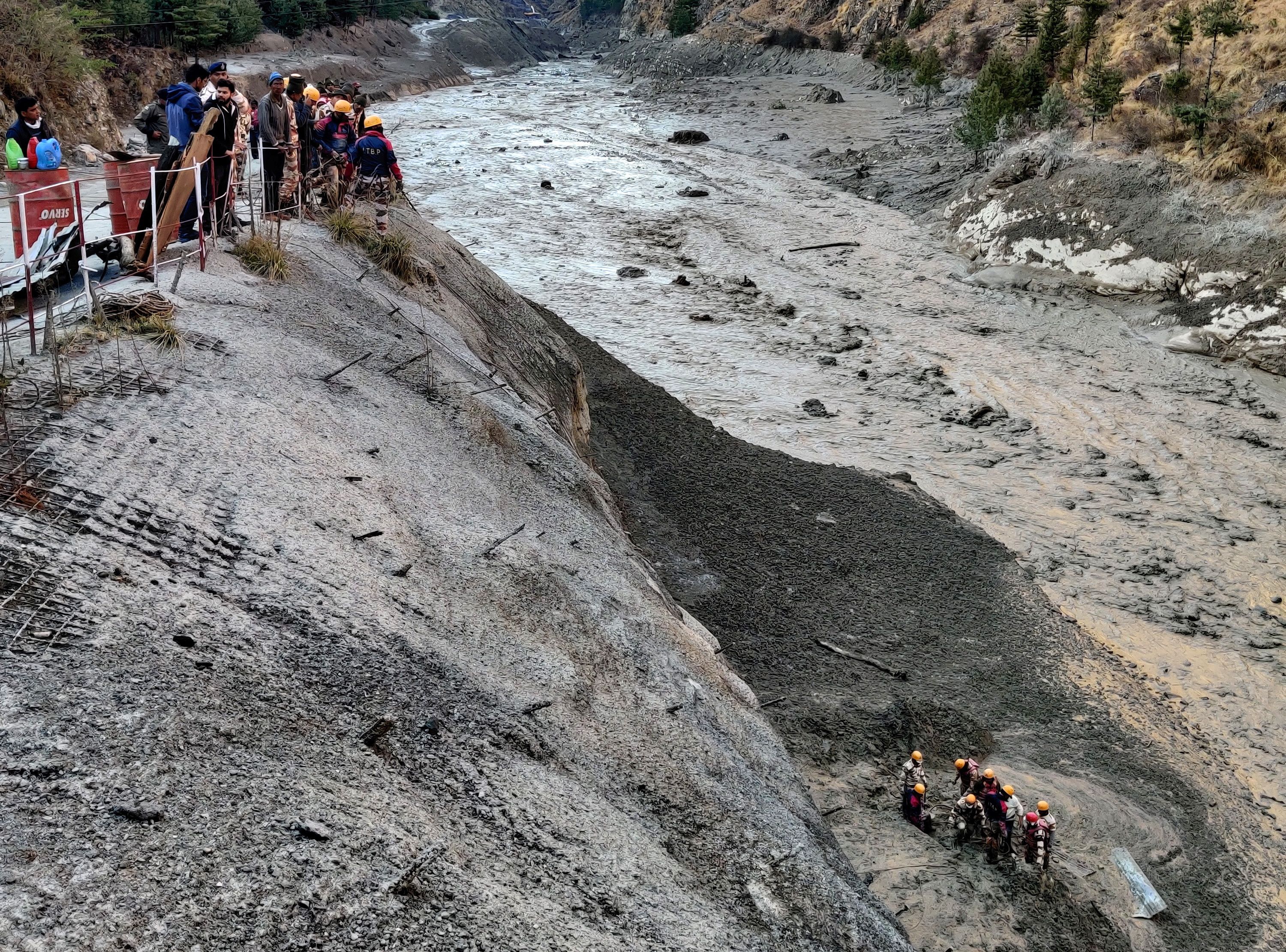 Members of Indo-Tibetan Border Police search for survivors after a Himalayan glacier broke and swept away a small hydroelectric dam, in Chormi