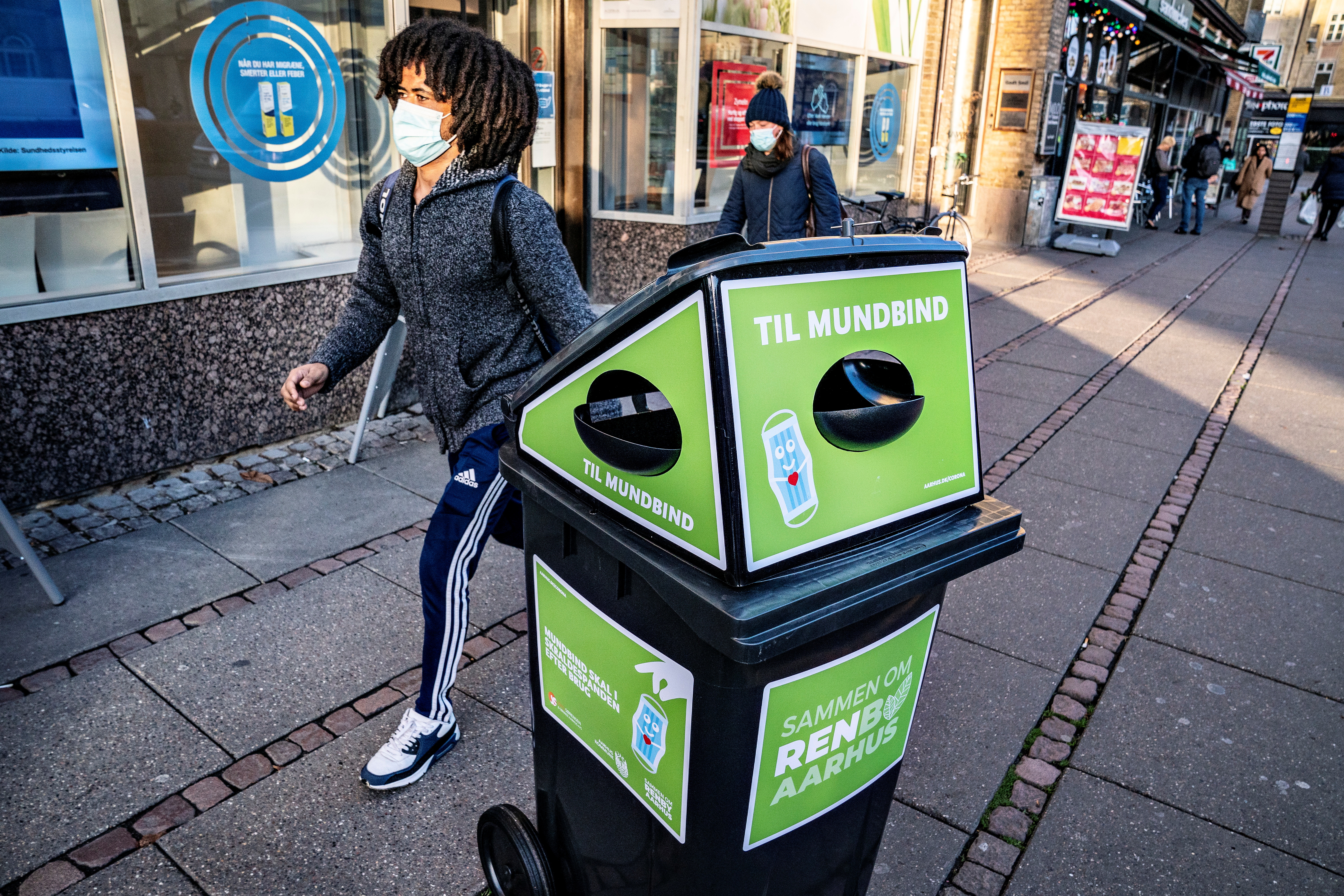 Pedestrians pass a waste bin for disposable masks in Aarhus, Denmark November 23, 2020. Ritzau Scanpix/Henning Bagger via REUTERS/File Photo