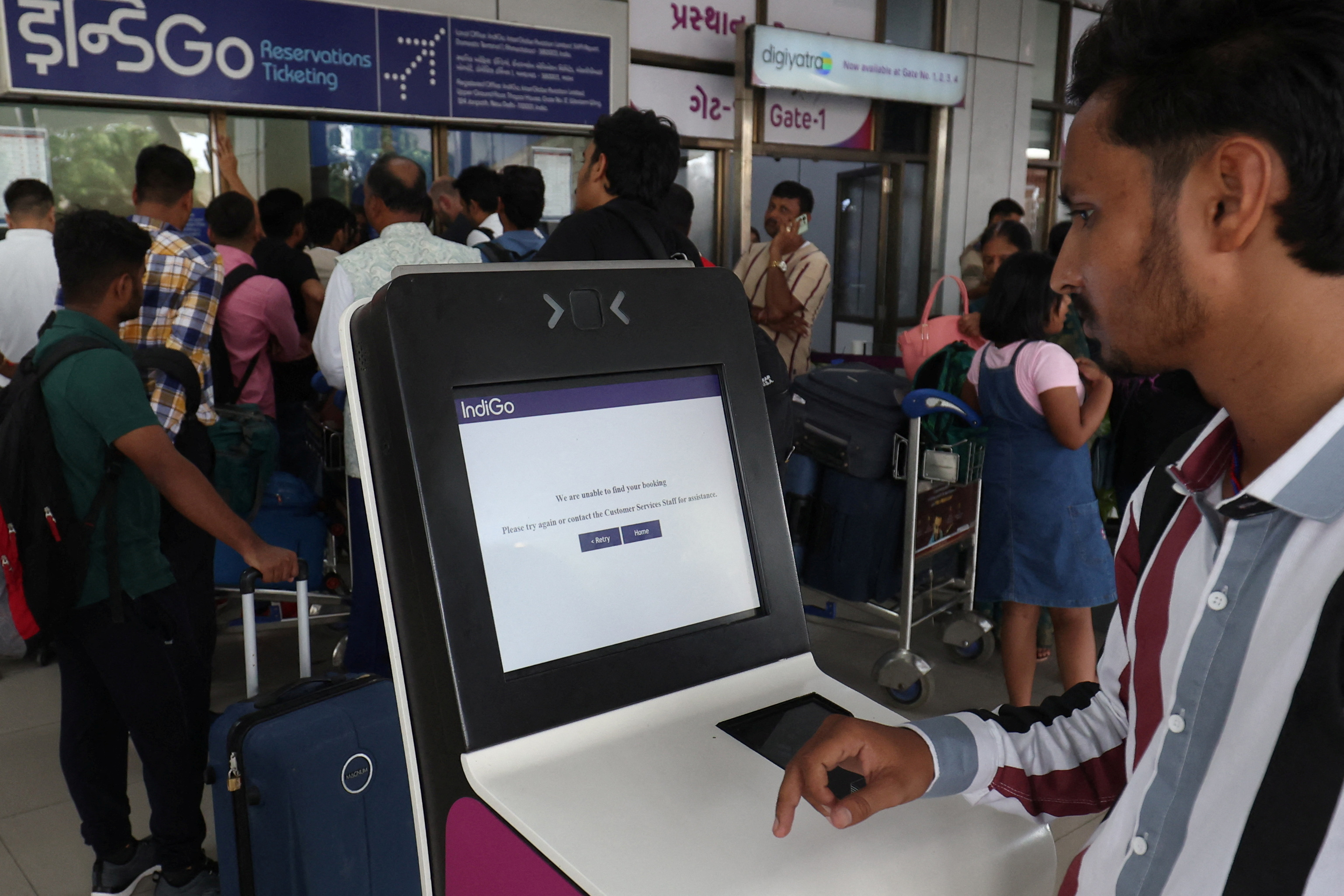 A passenger reads a message after he tried to use a self-check-in kiosk at a departure area at Sardar Vallabhbhai Patel International Airport following a global IT outage, in Ahmedabad