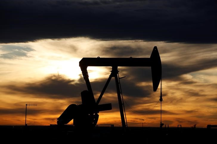 The sun sets behind a crude oil pump jack on a drill pad in the Permian Basin in Loving County
