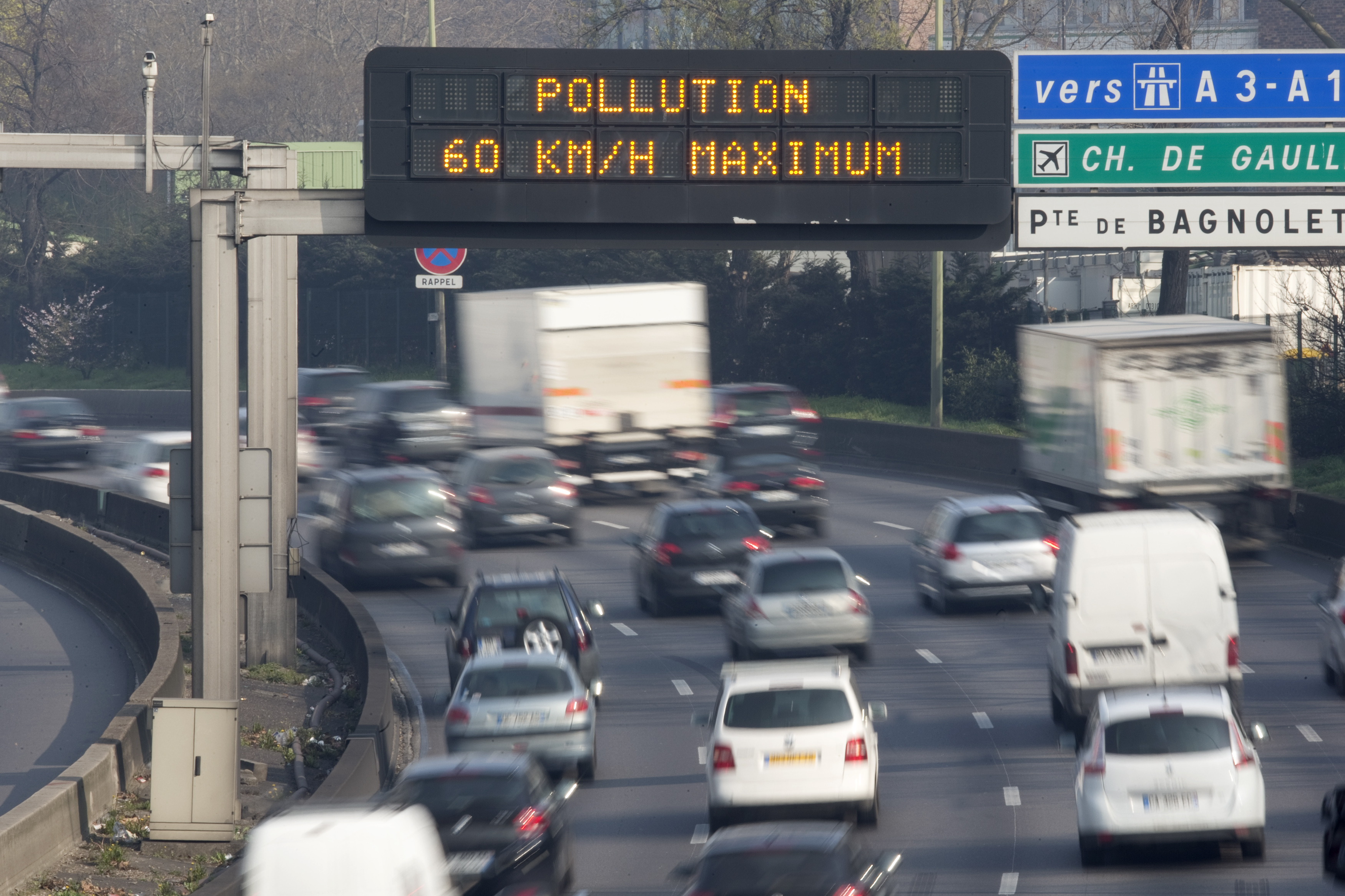 An electronic road sign reads "Pollution, speed limit 60kms" on the Paris ring road