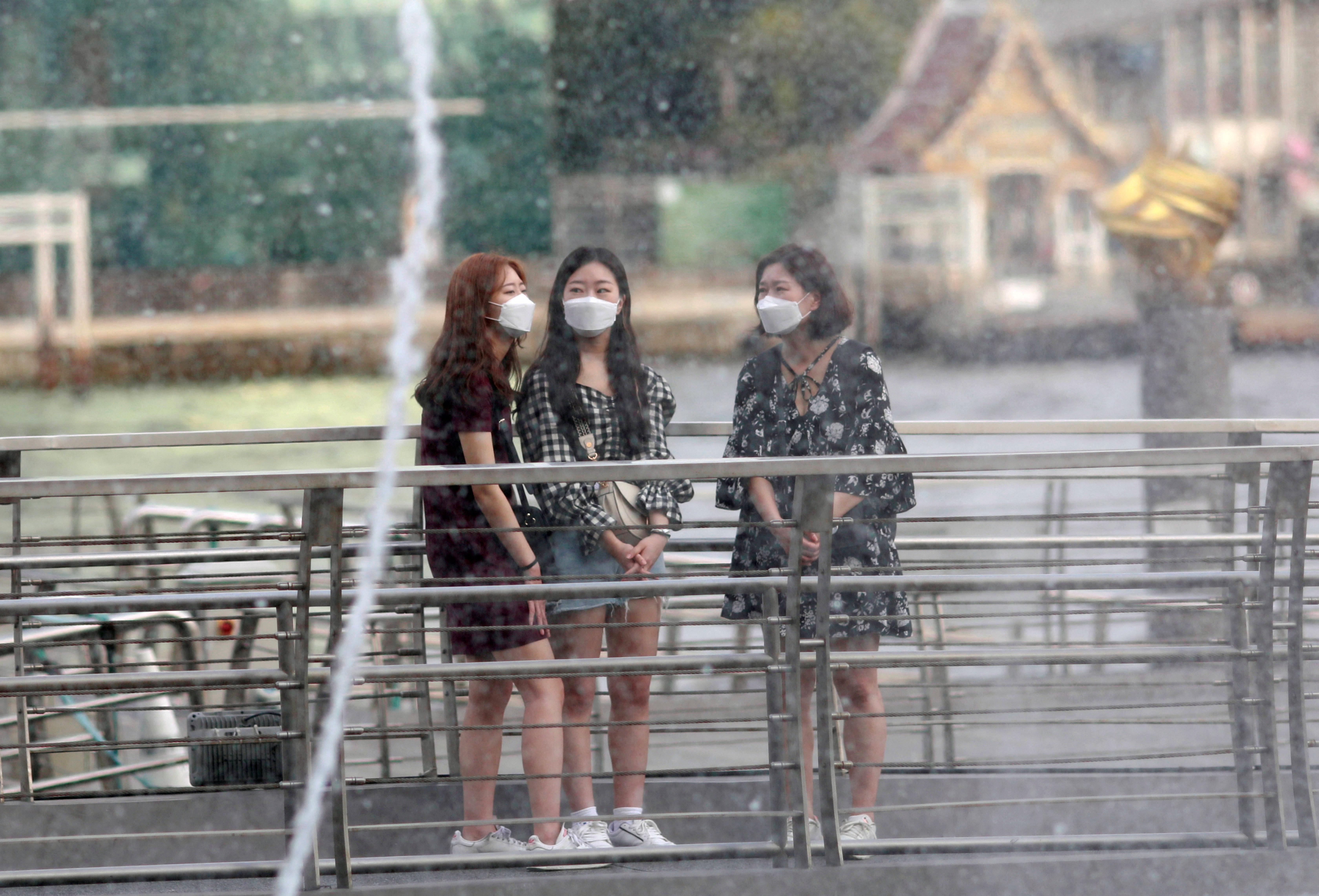 Tourists wear masks as they visit a shopping center in Bangkok