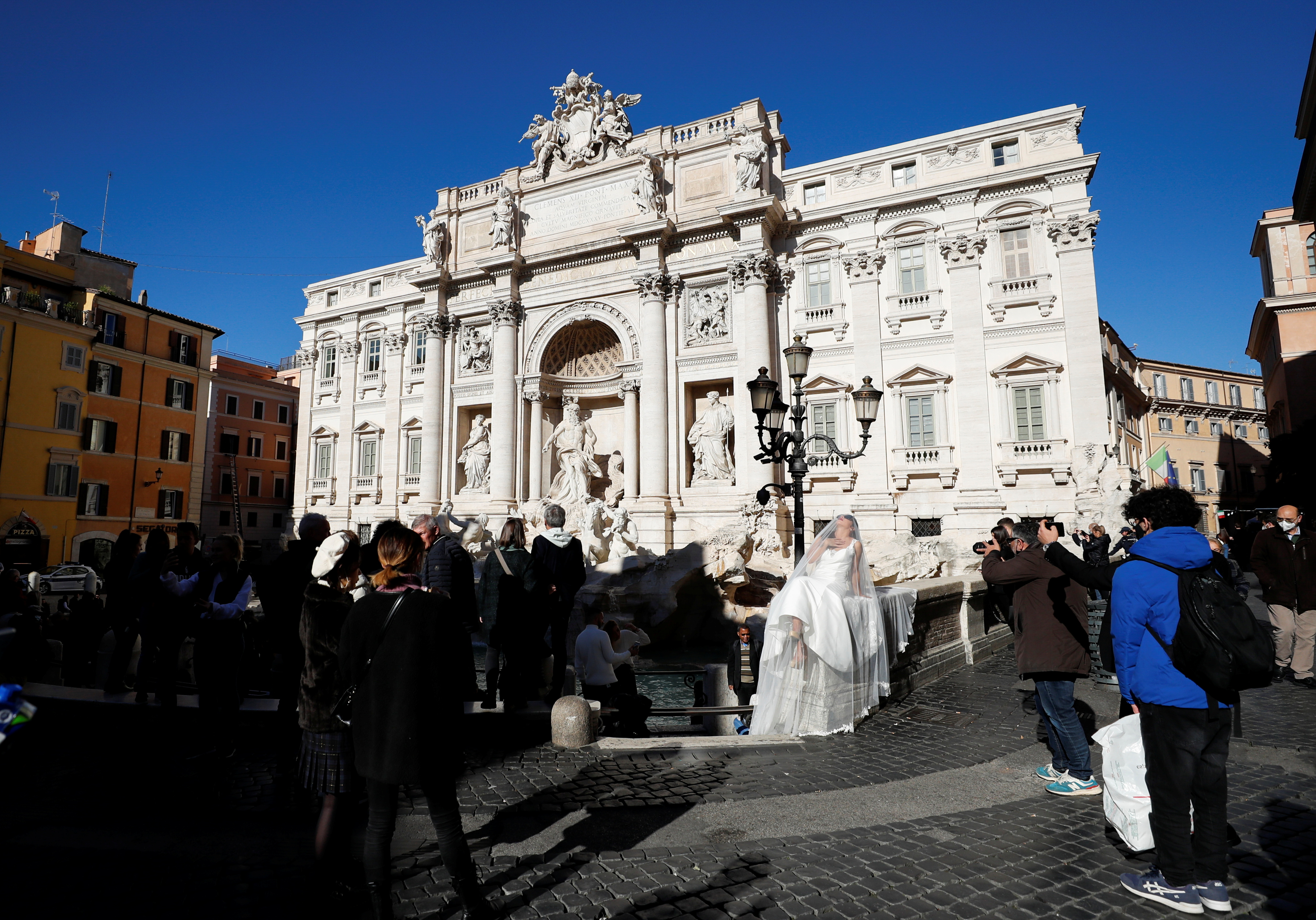 People walk in front of the Trevi Fountain, as the government discusses more stringent rules for the coronavirus disease (COVID-19) health pass known as a Green Pass, in Rome, Italy November 24, 2021. REUTERS/Yara Nardi