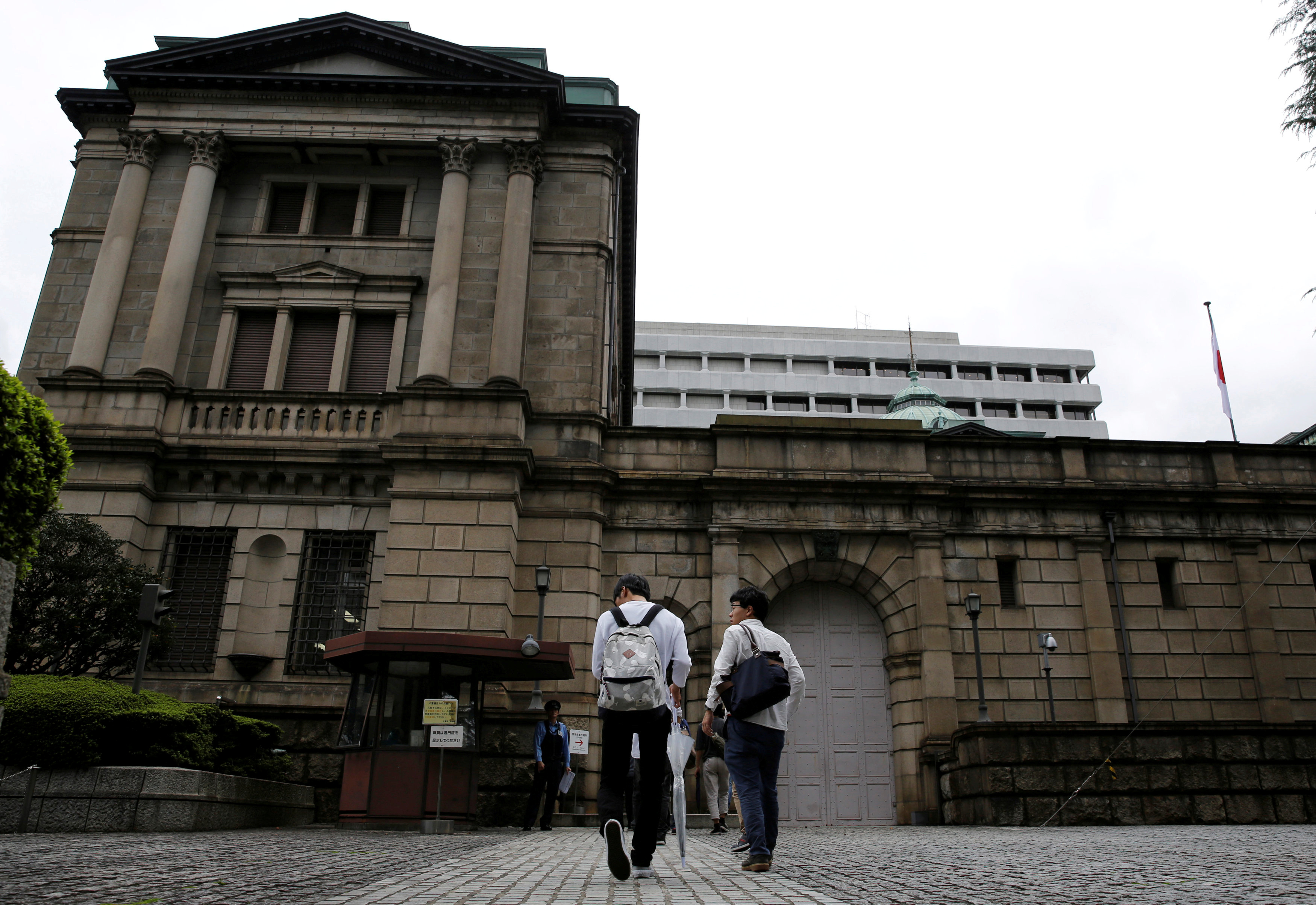 Men walk toward the Bank of Japan (BOJ) building in Tokyo