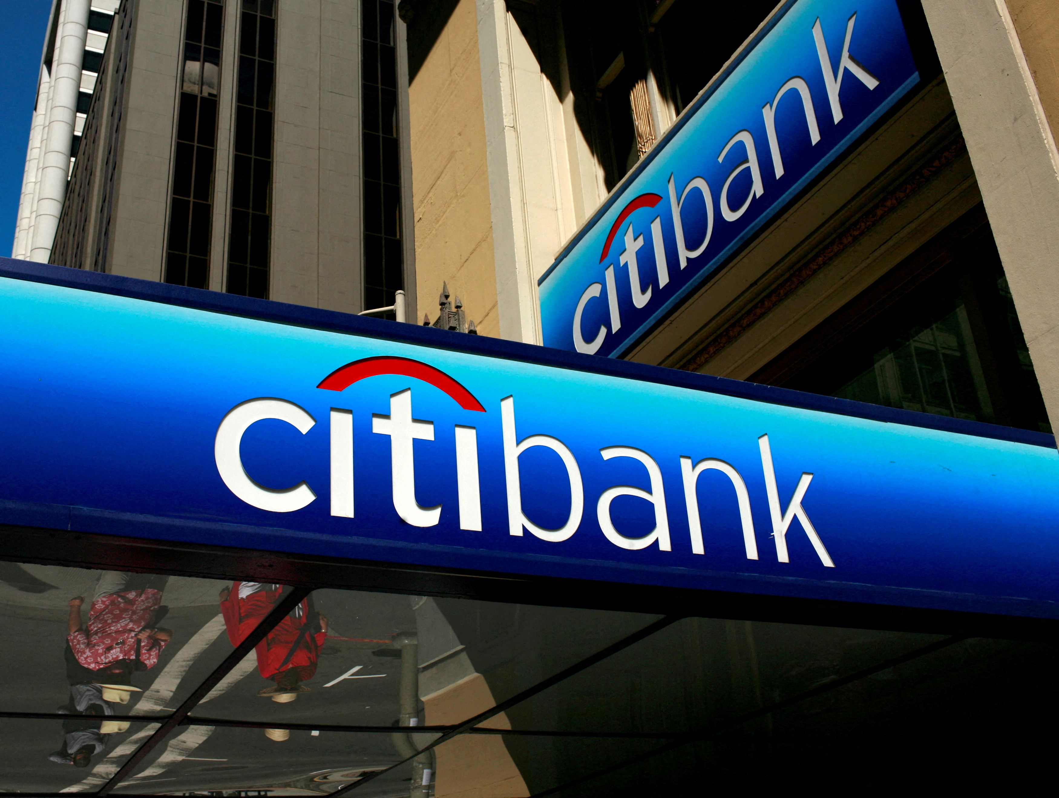 People walk beneath a Citibank branch logo in the financial district of San Francisco, California