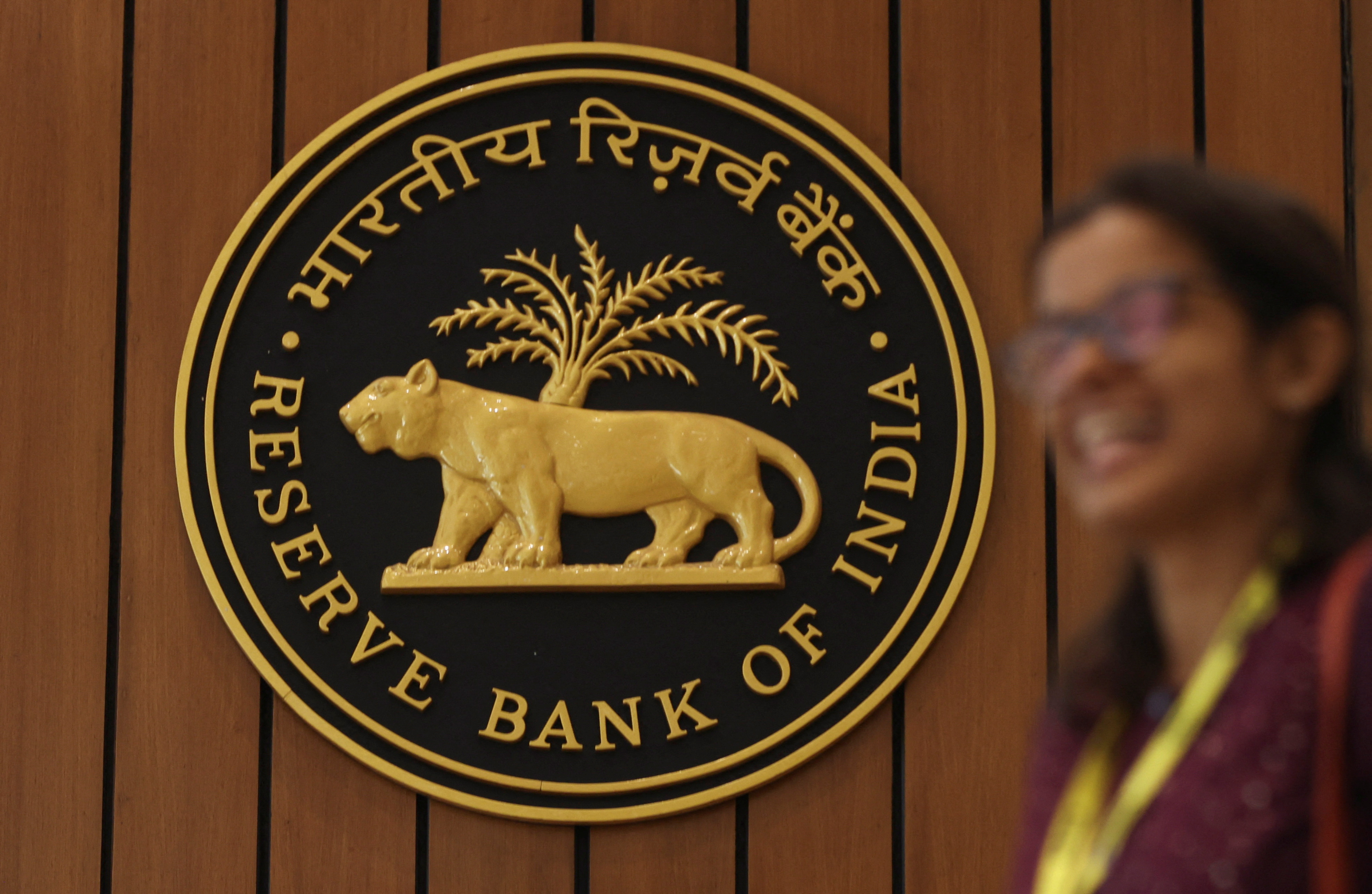 A woman walks past the Reserve Bank of India (RBI) logo inside its headquarters in Mumbai