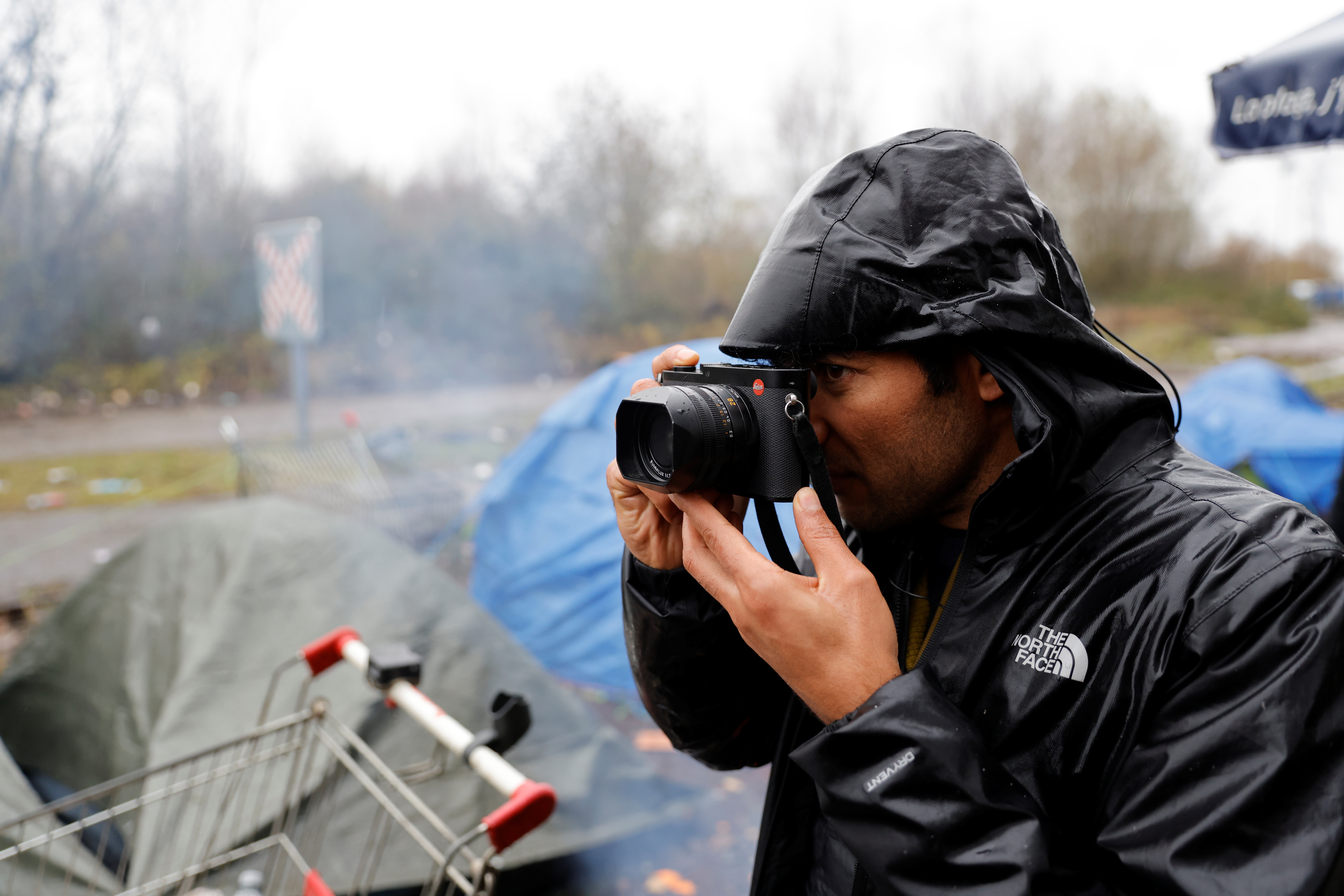 Afghan refugee and photographer Abdul Saboor takes pictures in a makeshifts migrant camp during an interview with Reuters in Loon-Plage, near Dunkirk, France, December 4, 2021. REUTERS/Pascal Rossignol