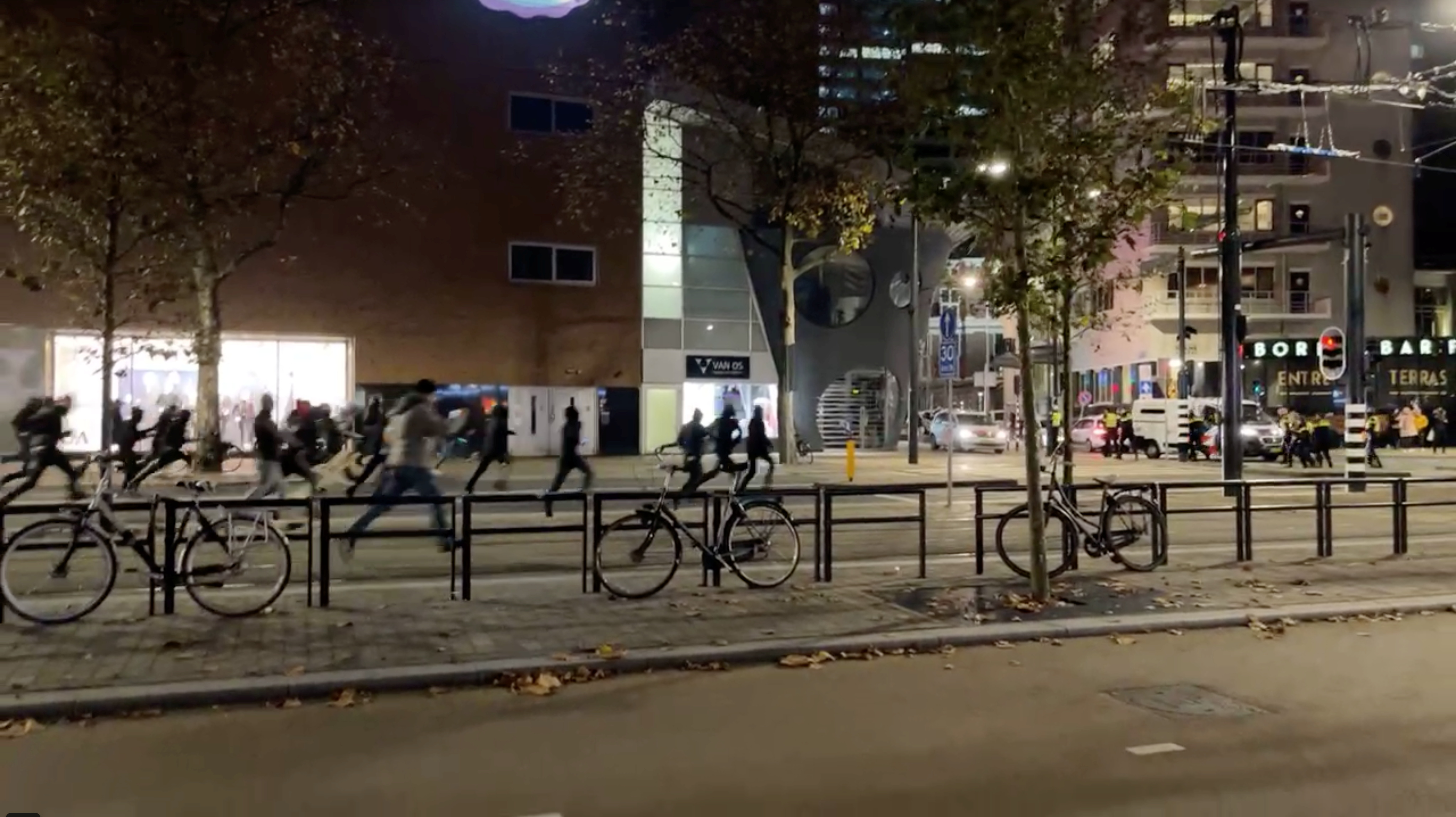 Protesters run towards police officers in Rotterdam