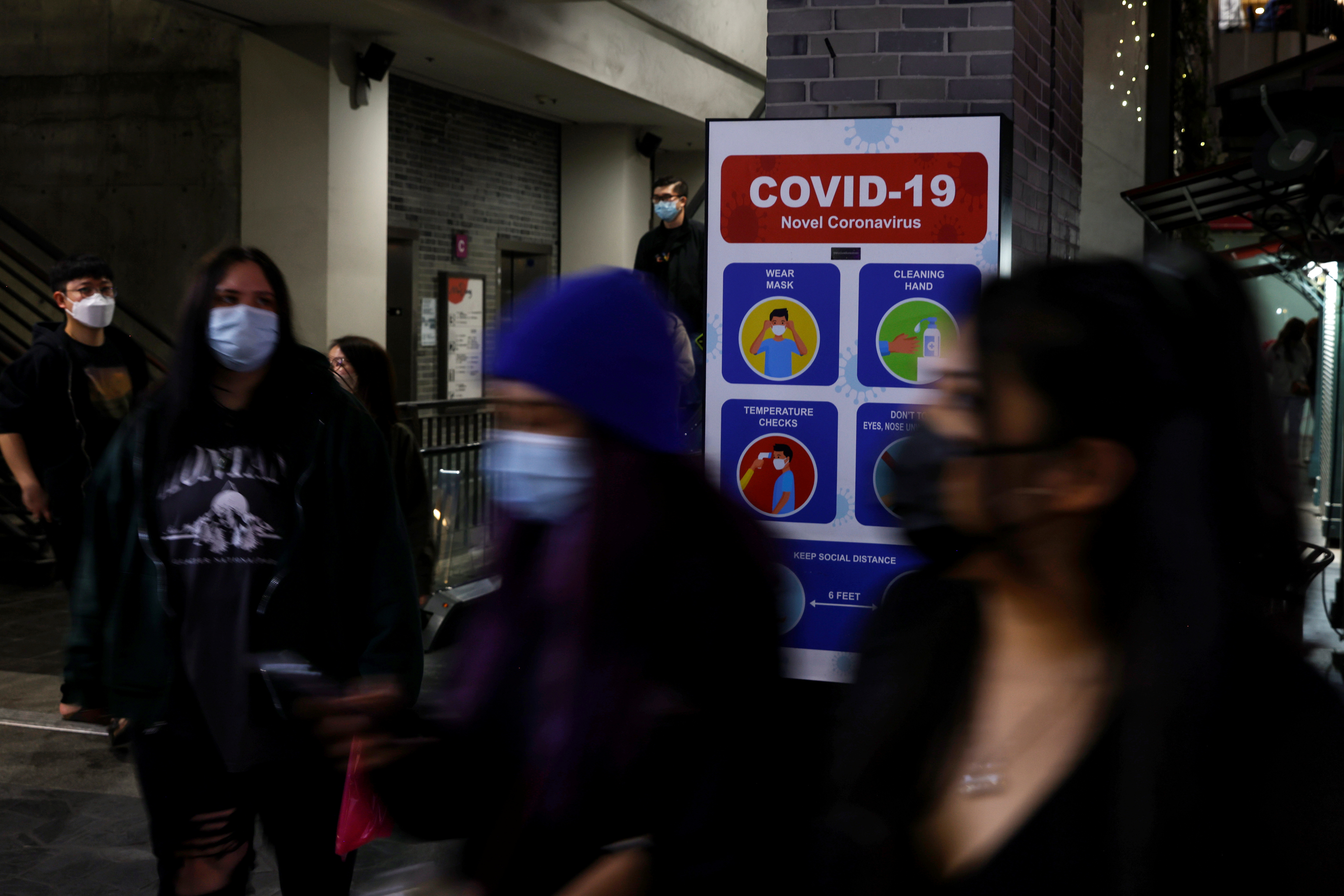People walk with protective face masks, amid the coronavirus disease (COVID-19) pandemic, in the Koreatown section of Los Angeles, California