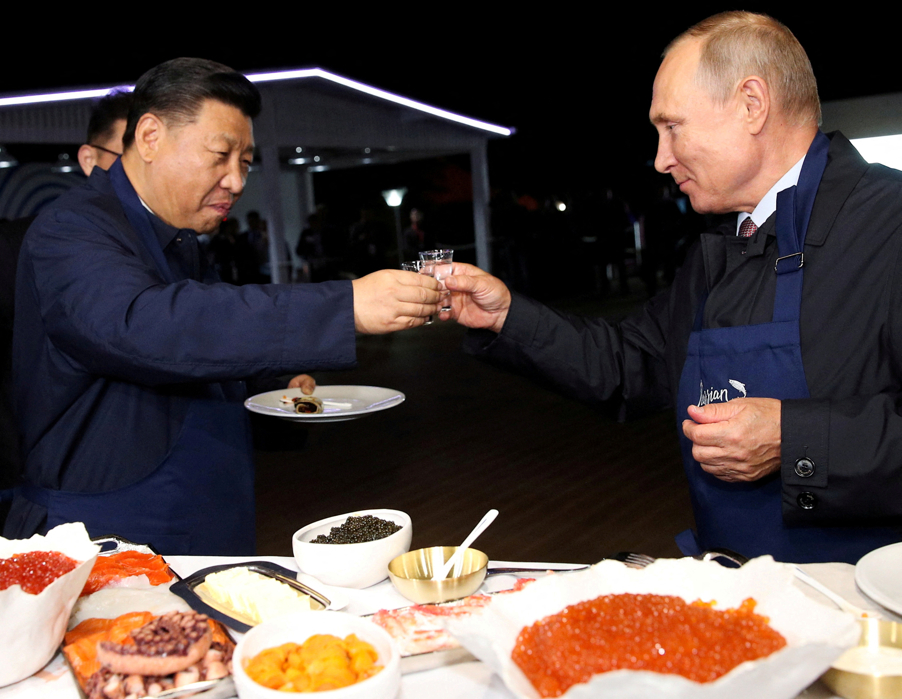 Russian President Vladimir Putin and Chinese President Xi Jinping toast during a visit to the Far East Street exhibition on the sidelines of the Eastern Economic Forum in Vladivostok