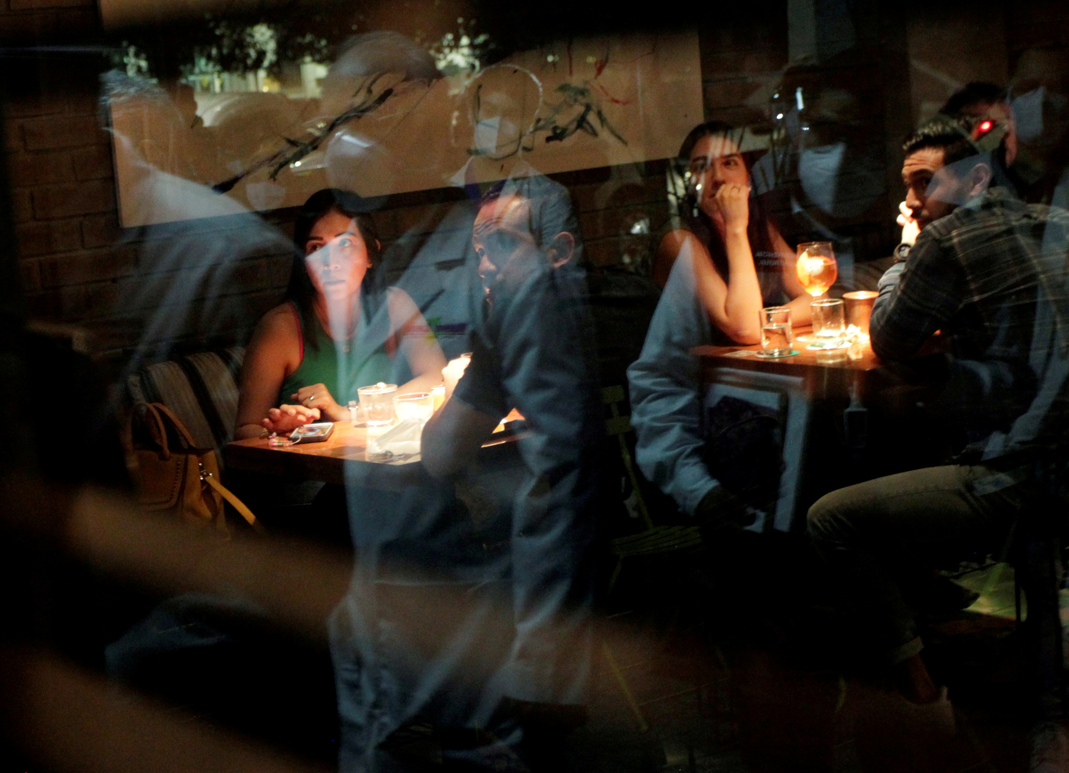 Medical workers are reflected on a window during a tour in nightclubs and restaurants to check that they do not exceed the allowed capacity, amid the coronavirus disease (COVID-19) outbreak, in San Pedro Garza Garcia, on the outskirts of Monterrey, Mexico July 24, 2021. Picture taken July 24, 2021. REUTERS/Daniel Becerril/File Photo