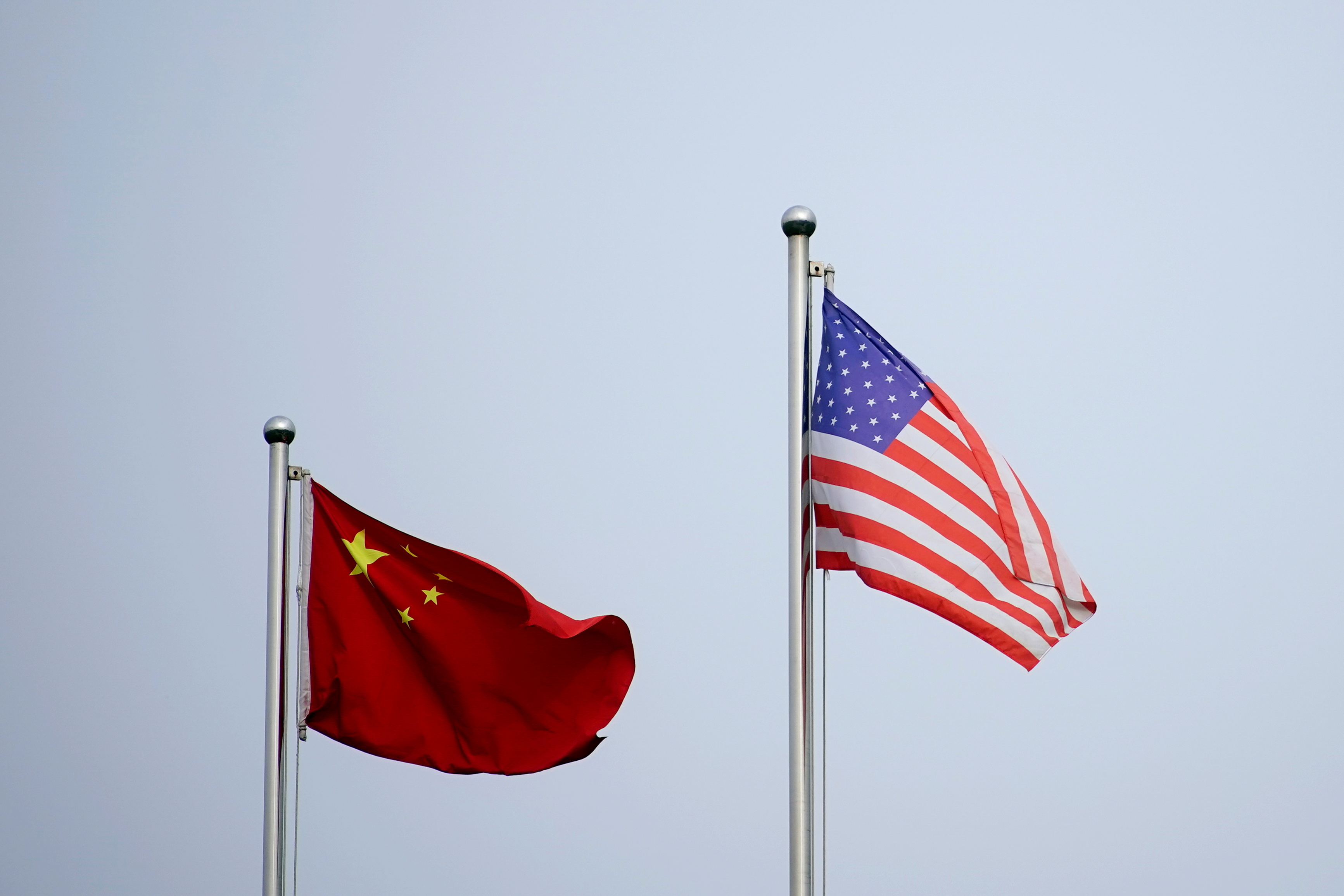 Chinese and U.S. flags flutter outside a company building in Shanghai, China April 14, 2021. REUTERS/Aly Song