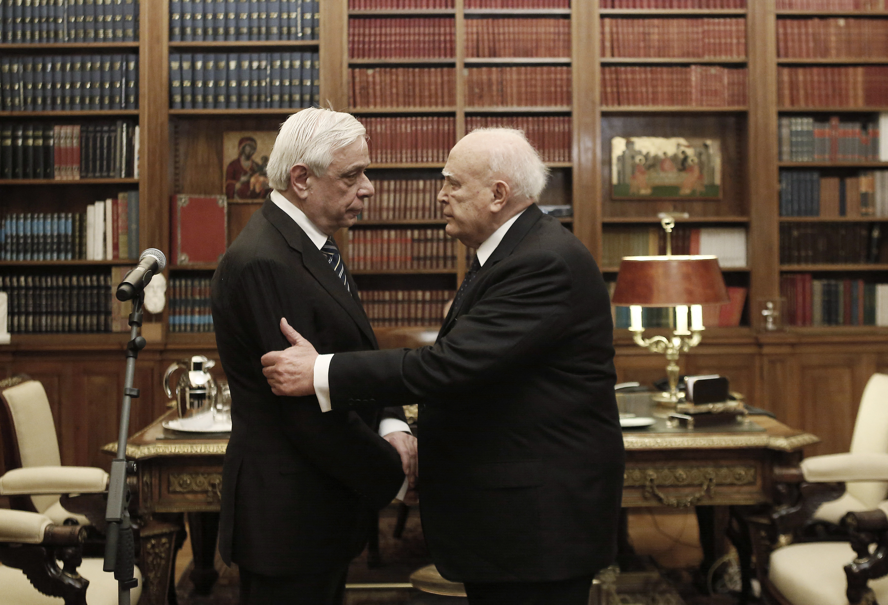 Outgoing Greek President Papoulias shakes hands with newly elected President Pavlopoulos during a handover ceremony at the Presidential Palace in Athens
