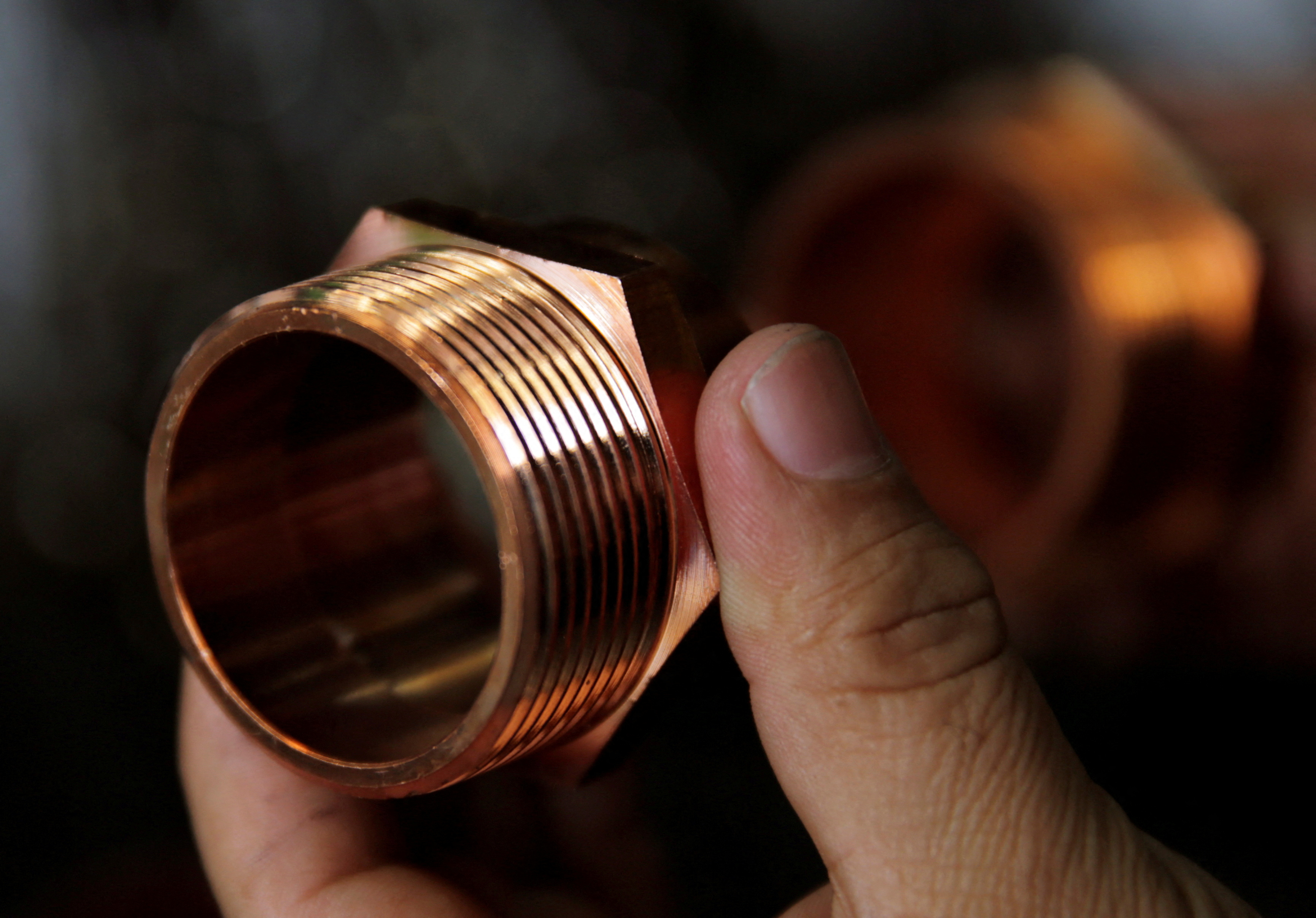 A vendor shows copper components used for plumbing seen on sale at the Surtidora Ferretera River Store in Mexico City
