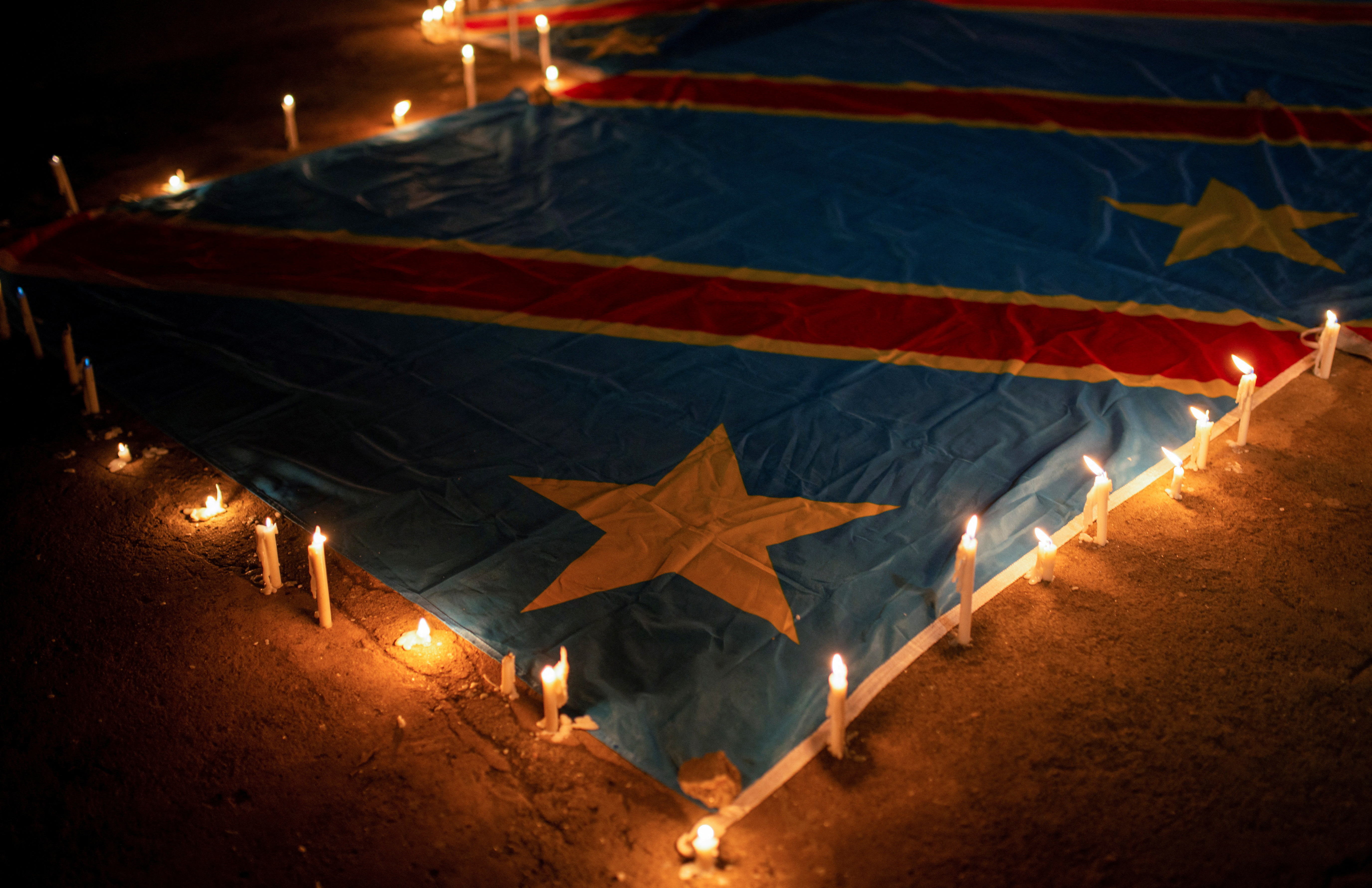 Candles are arranged on a Congolese national flag during a vigil in memory of the civilians killed in the recent conflict between FARDC and rebel forces, in Goma