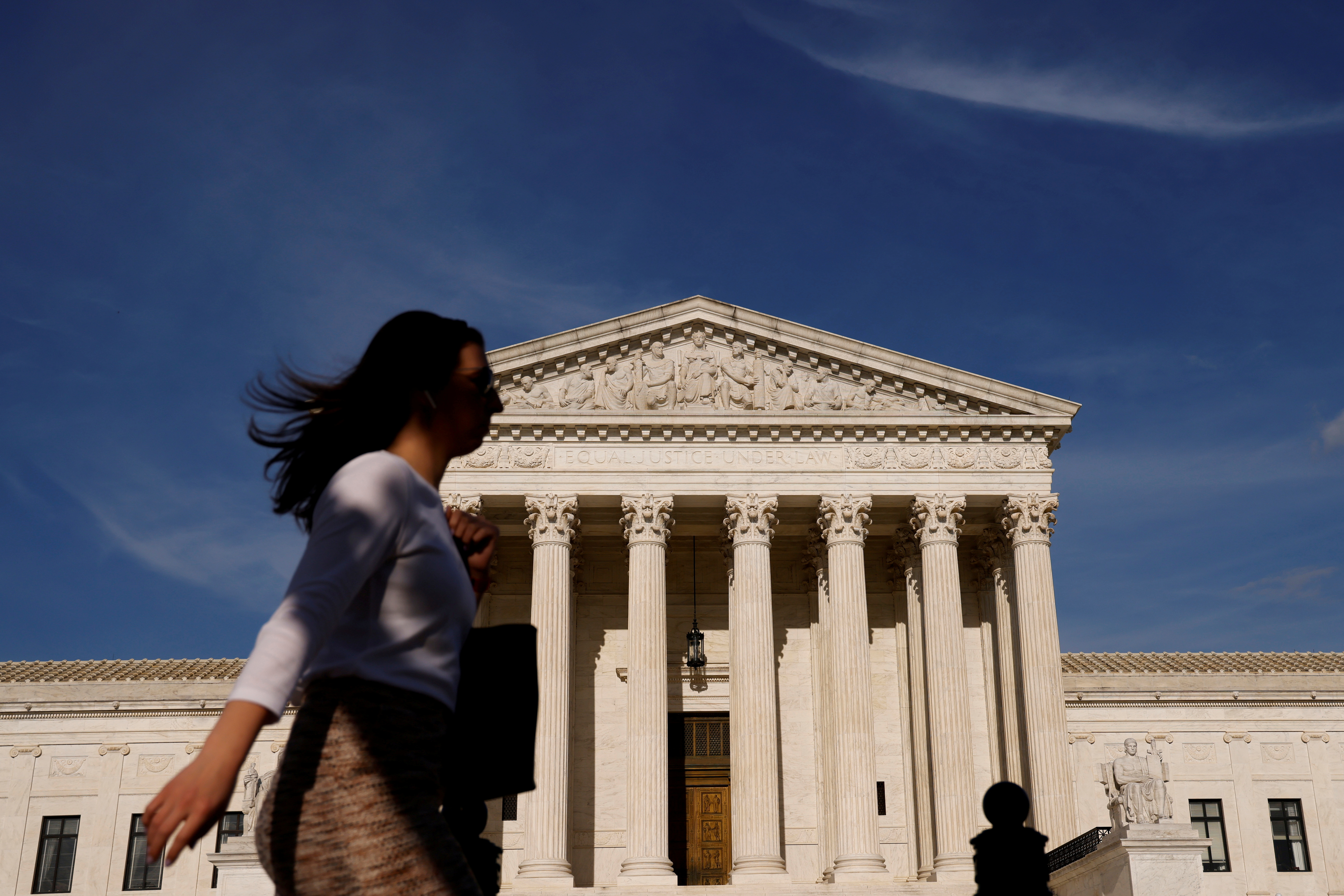 A woman walks past the U.S. Supreme Court building in Washington
