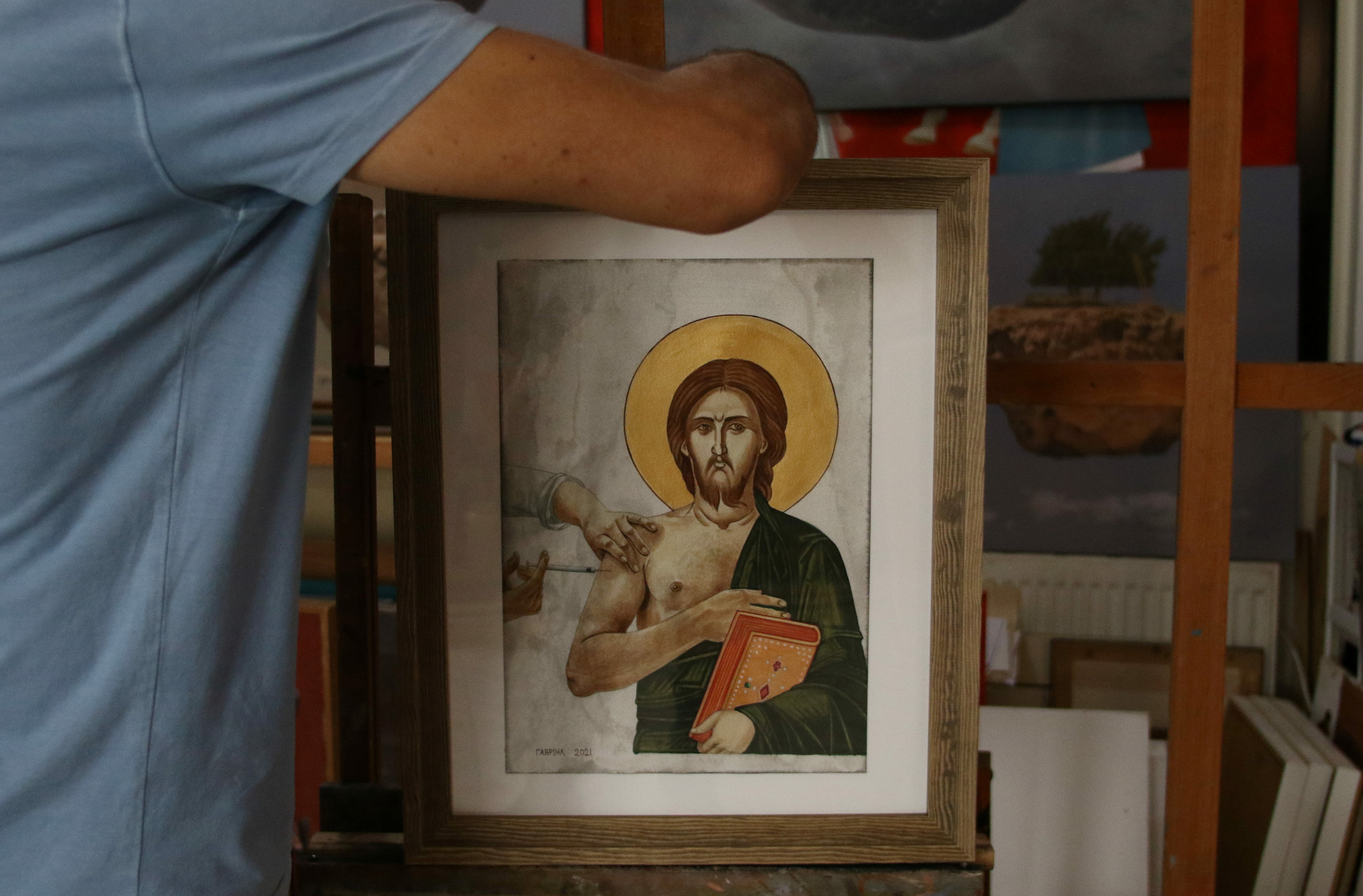 George Gavriel places a painting on an easel in his home studio in Kokkinotrimithia, Cyprus, October 15, 2021. REUTERS/Yiannis Kourtoglou